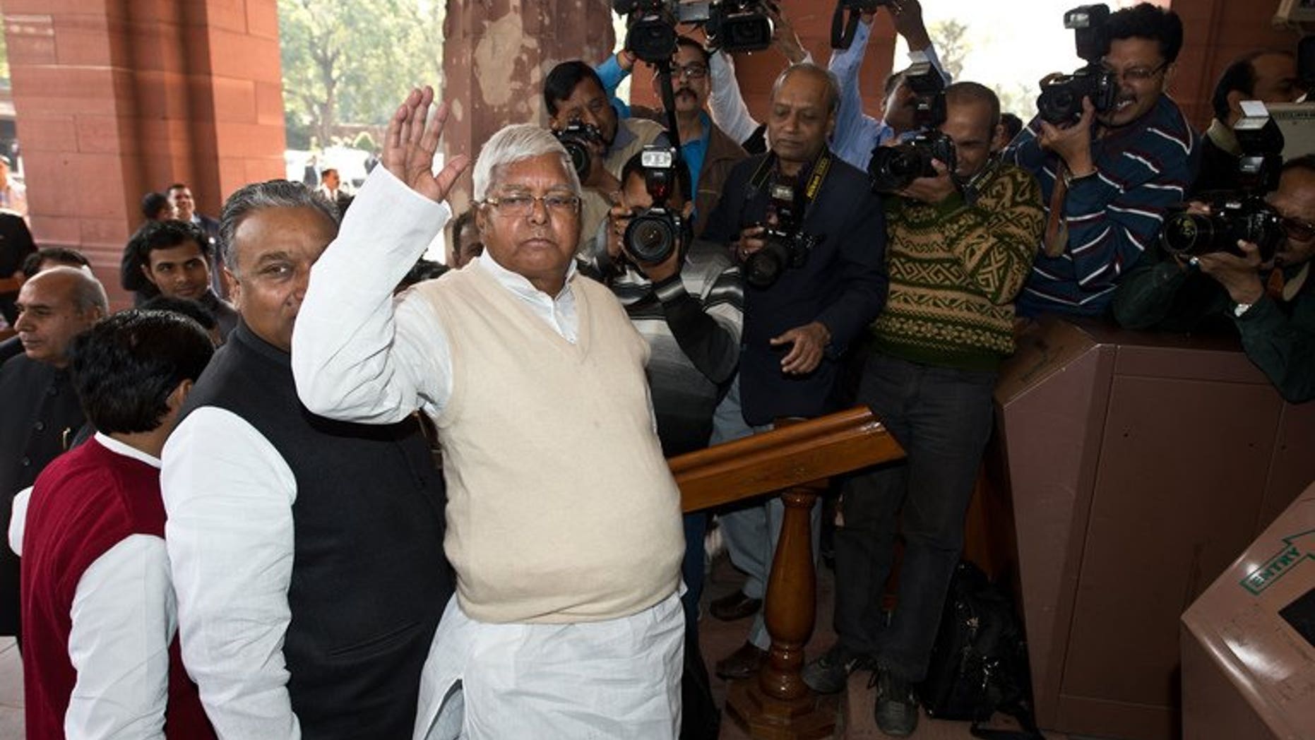 Former Railway Minister Lalu Prasad Yadav (C) arrives at Parliament for the unveiling of the Railway Budget in New Delhi on February 26, 2013.