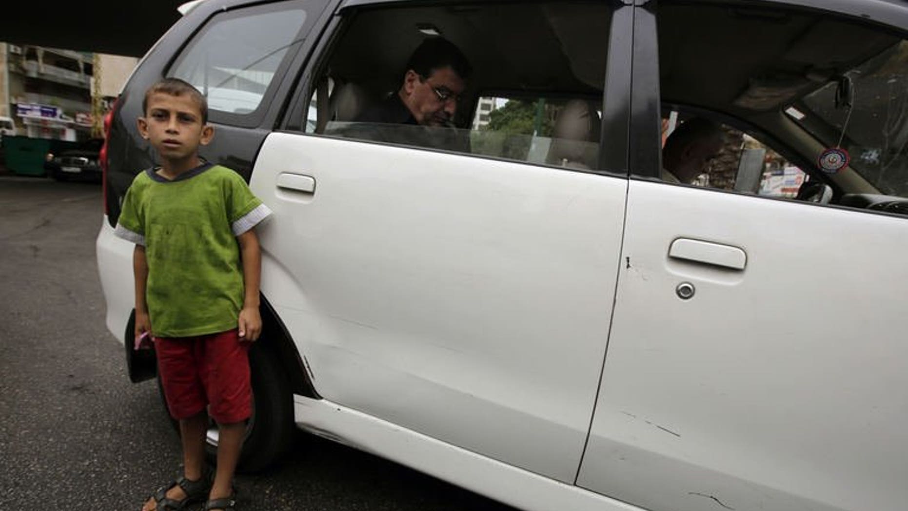A Syrian refugee child from the northern city of Aleppo sells chewing gum in a traffic jam on a street in the Lebanese capital, Beirut, on Spetember 18, 2013.