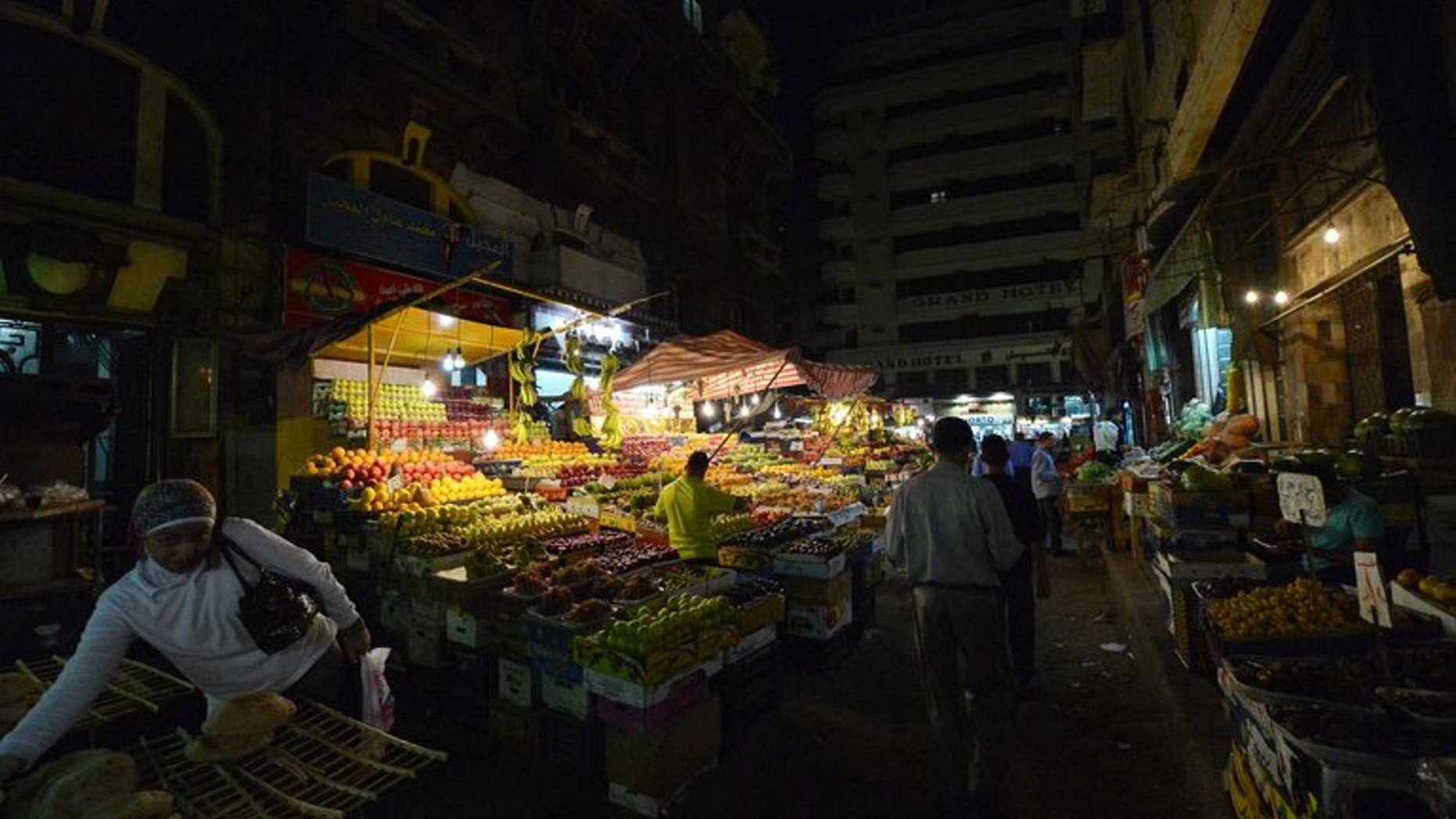 Egyptians walk at a fruit market in downtown Cairo on October 18, 2012. Egypt will impose a sharp cut in the price of fruits and vegetables if they do not come down on their own by next week, the supply and domestic trade minister said Tuesday.