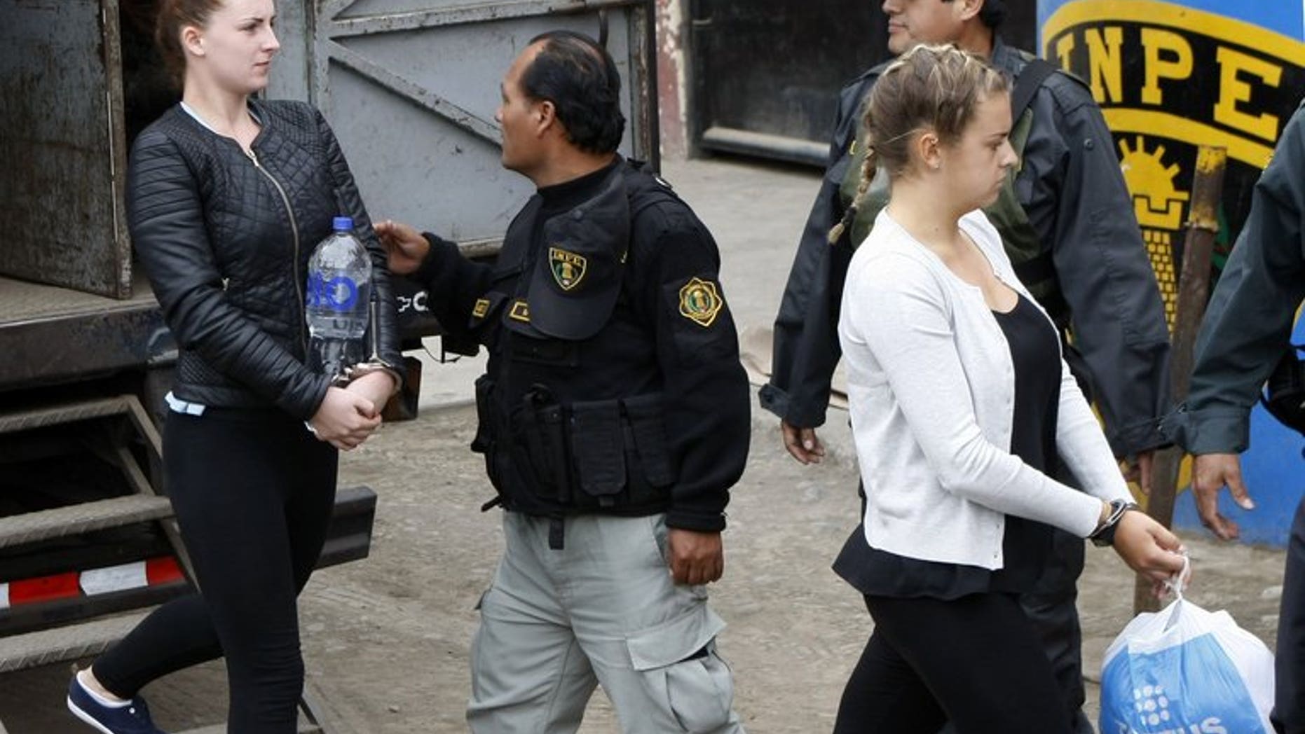 Irishwoman Michaella McCollum (L) and Briton Melissa Reid (R) walk into the Sarita Colonia Jailhouse Court in the port of Callao, west of Lima, on September 24, 2013, where both pleaded guilty to attempting to sneak 11 kilos of cocaine out of the country and into Spain