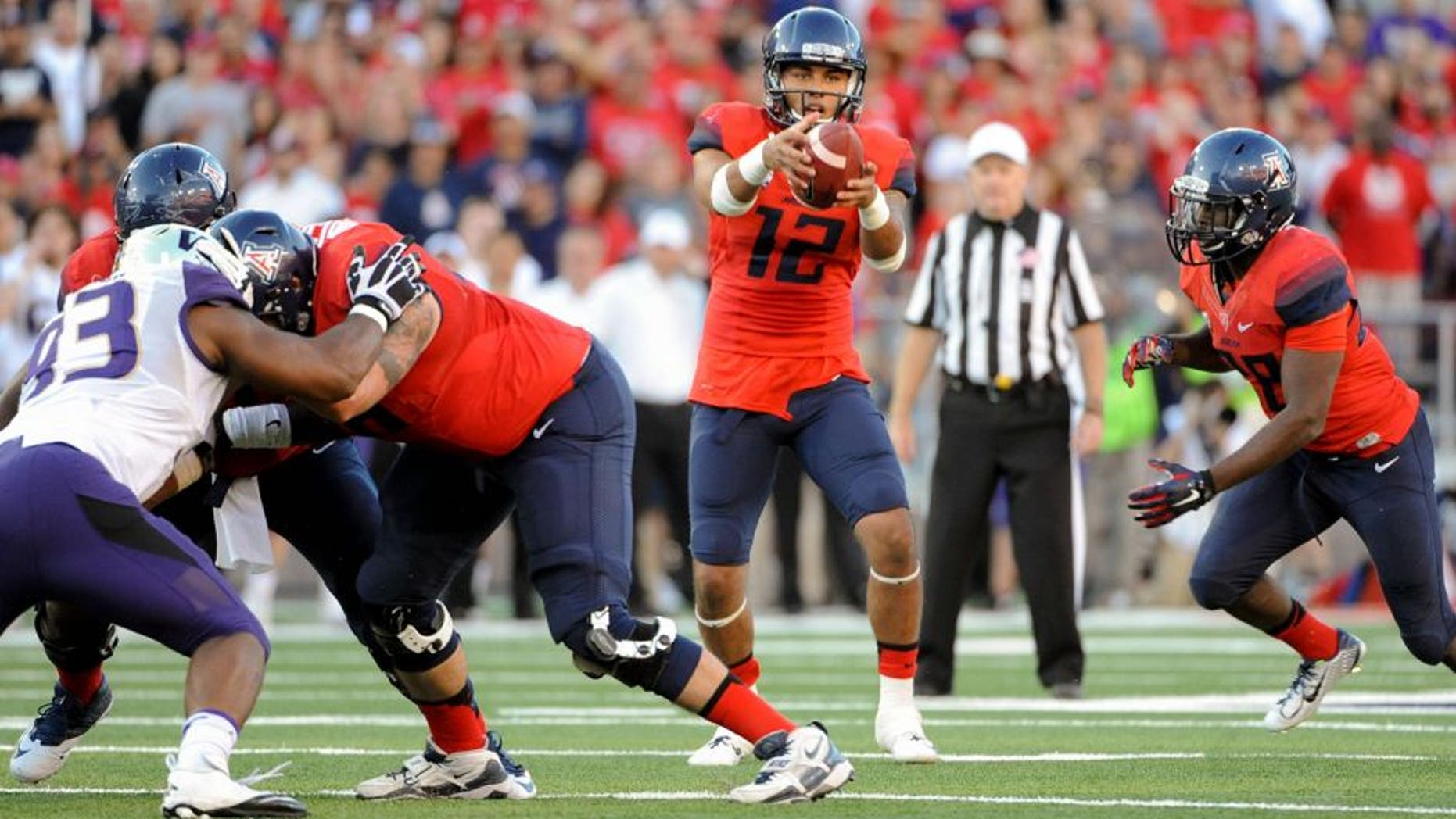Nov 15, 2014; Tucson, AZ, USA; Arizona Wildcats quarterback Anu Solomon (12) takes the snap during the fourth quarter against the Washington Huskies at Arizona Stadium. Arizona won 27-26. Mandatory Credit: Casey Sapio-USA TODAY Sports