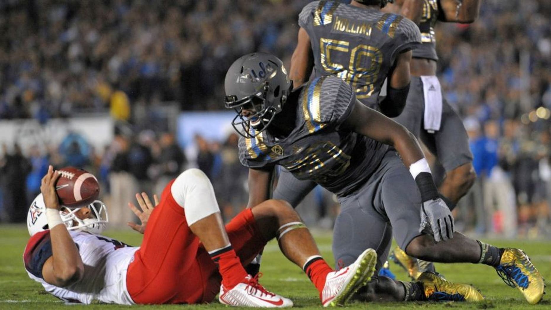 Nov 1, 2014; Pasadena, CA, USA; UCLA Bruins linebacker Myles Jack (30)reacts after sacking Arizona Wildcats quarterback Anu Solomon (left) during the first quarter at Rose Bowl. Mandatory Credit: Jake Roth-USA TODAY Sports