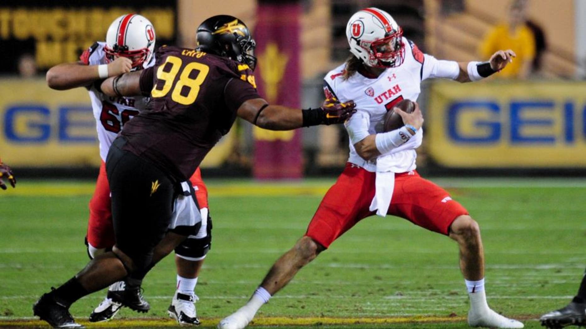 Nov 1, 2014; Tempe, AZ, USA; Utah Utes quarterback Travis Wilson (7) breaks a tacle by Arizona State Sun Devils defensive tackle Mo Latu (98) during the first half at Sun Devil Stadium. Mandatory Credit: Matt Kartozian-USA TODAY Sports