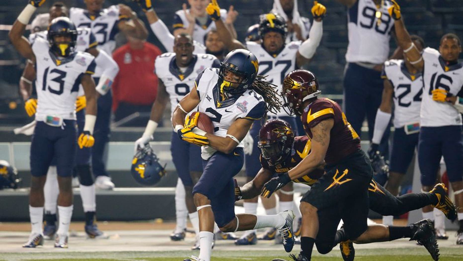 West Virginia wide receiver Ka'Raun White (2) pulls in a pass as Arizona State defensive back Kweishi Brown (10) gives chase during the first half of the Cactus Bowl NCAA college football game, Saturday, Jan. 2, 2016, in Phoenix. (AP Photo/Ross D. Franklin)