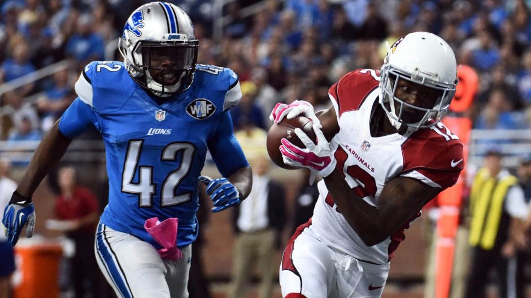 Oct 11, 2015; Detroit, MI, USA; Arizona Cardinals wide receiver John Brown (12) completes a pass for a touchdown during the second quarter while being pressured by Detroit Lions strong safety Isa Abdul-Quddus (42) at Ford Field. Mandatory Credit: Tim Fuller-USA TODAY Sports