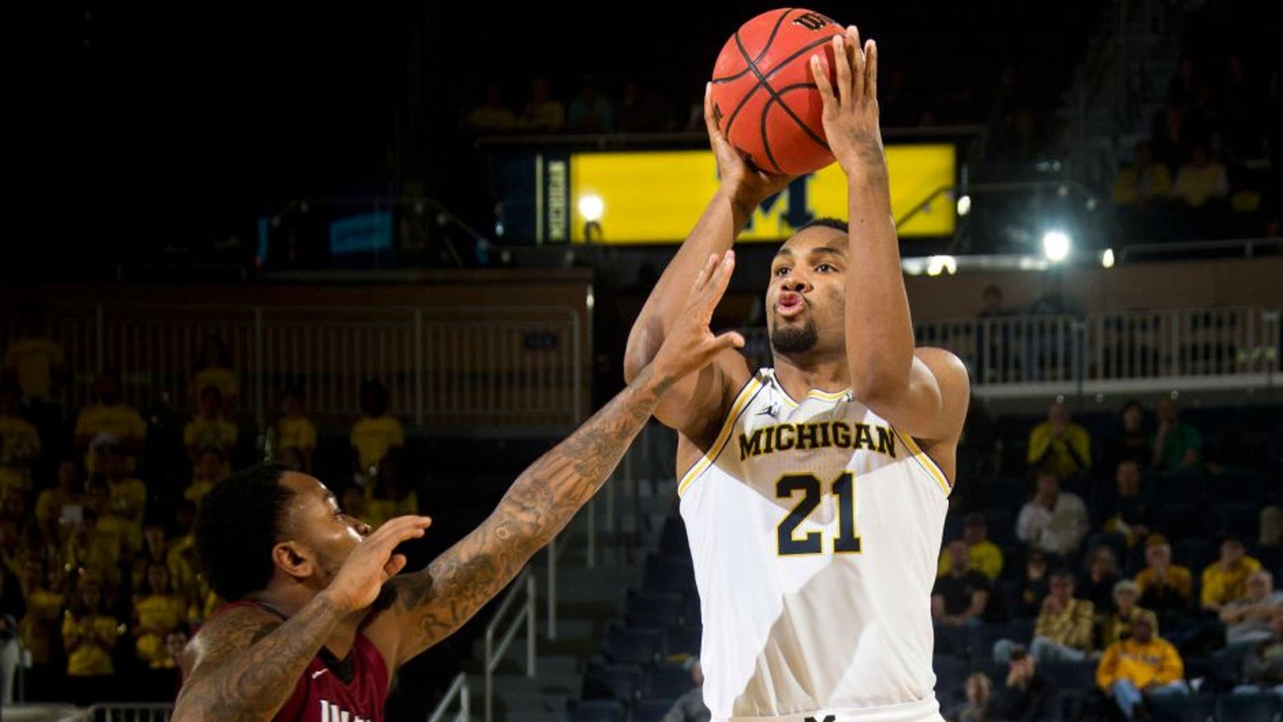 IUPUI guard Darell Combs, left, defends a jump shot from Michigan guard Zak Irvin (21) in the second half of an NCAA college basketball game at Crisler Center in Ann Arbor, Mich., Sunday, Nov. 13, 2016. Michigan won 77-65. (AP Photo/Tony Ding)