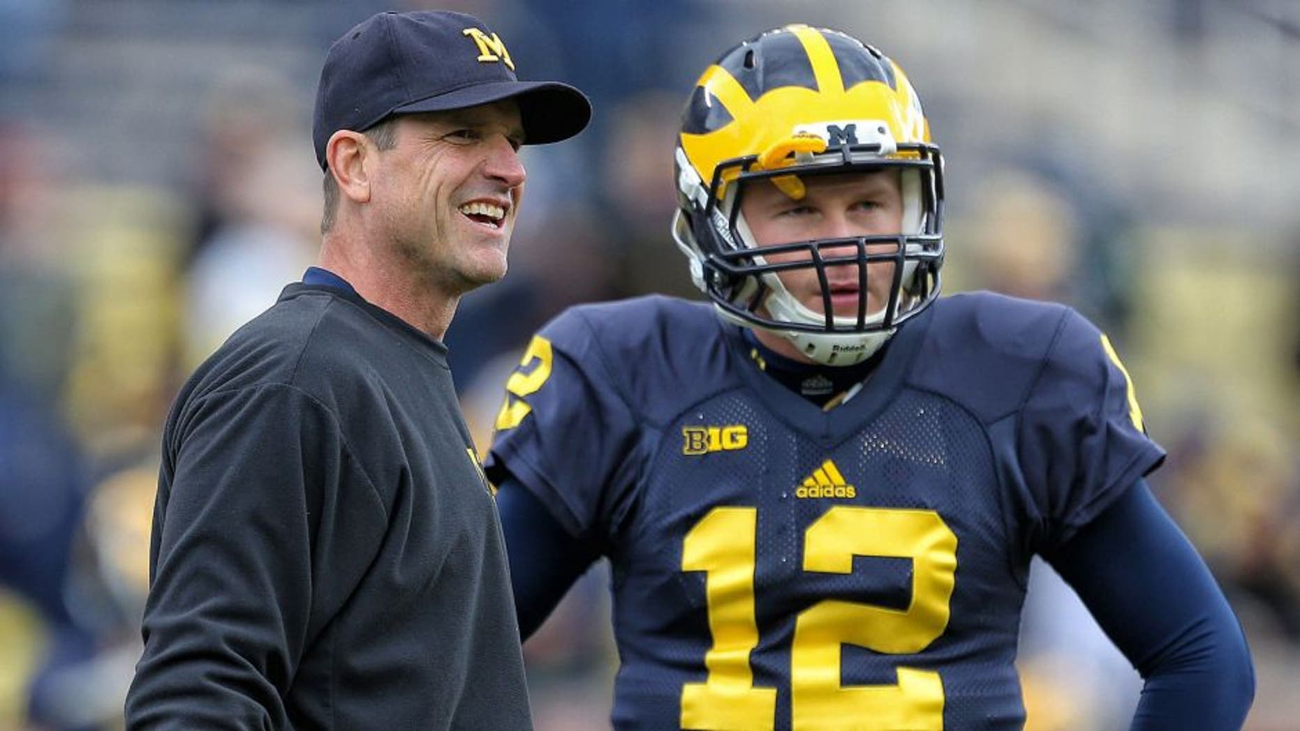 Oct 17, 2015; Ann Arbor, MI, USA; Michigan Wolverines head coach Jim Harbaugh talks to Michigan Wolverines quarterback Alex Malzone (12) prior to a game against the Michigan State Spartans at Michigan Stadium. Mandatory Credit: Mike Carter-USA TODAY Sports