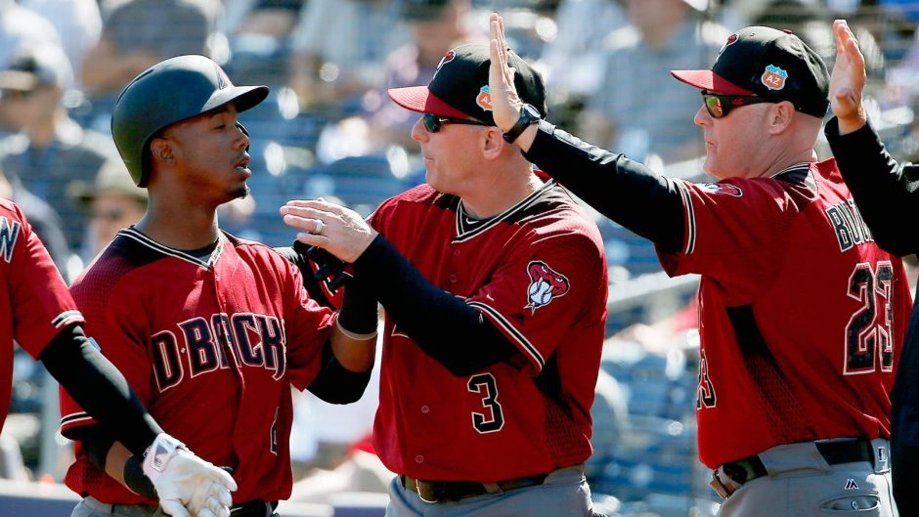 Arizona Diamondbacks' Jean Segura, left, is congratulated by manager Chip Hale (3) and pitching coach Mike Butcher (23) after scoring a run against the San Diego Padres during the second inning of a spring training baseball game Tuesday, March 8, 2016, in Peoria, Ariz. (AP Photo/Ross D. Franklin)