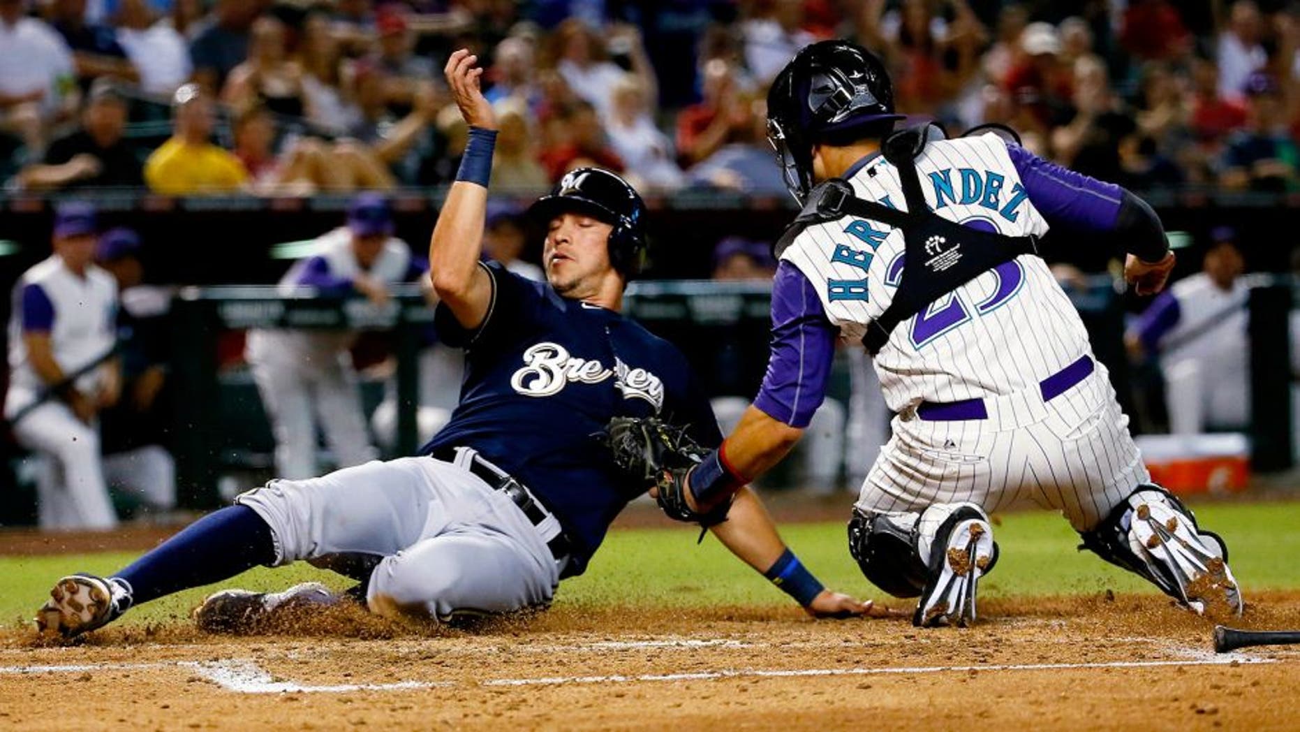 Milwaukee Brewers' Hernan Perez is tagged out at the plate by Arizona Diamondbacks' Oscar Hernandez while trying to score on a ground out by Gerardo Parra during the third inning of a baseball game, Thursday, July 23, 2015, in Phoenix. (AP Photo/Matt York)