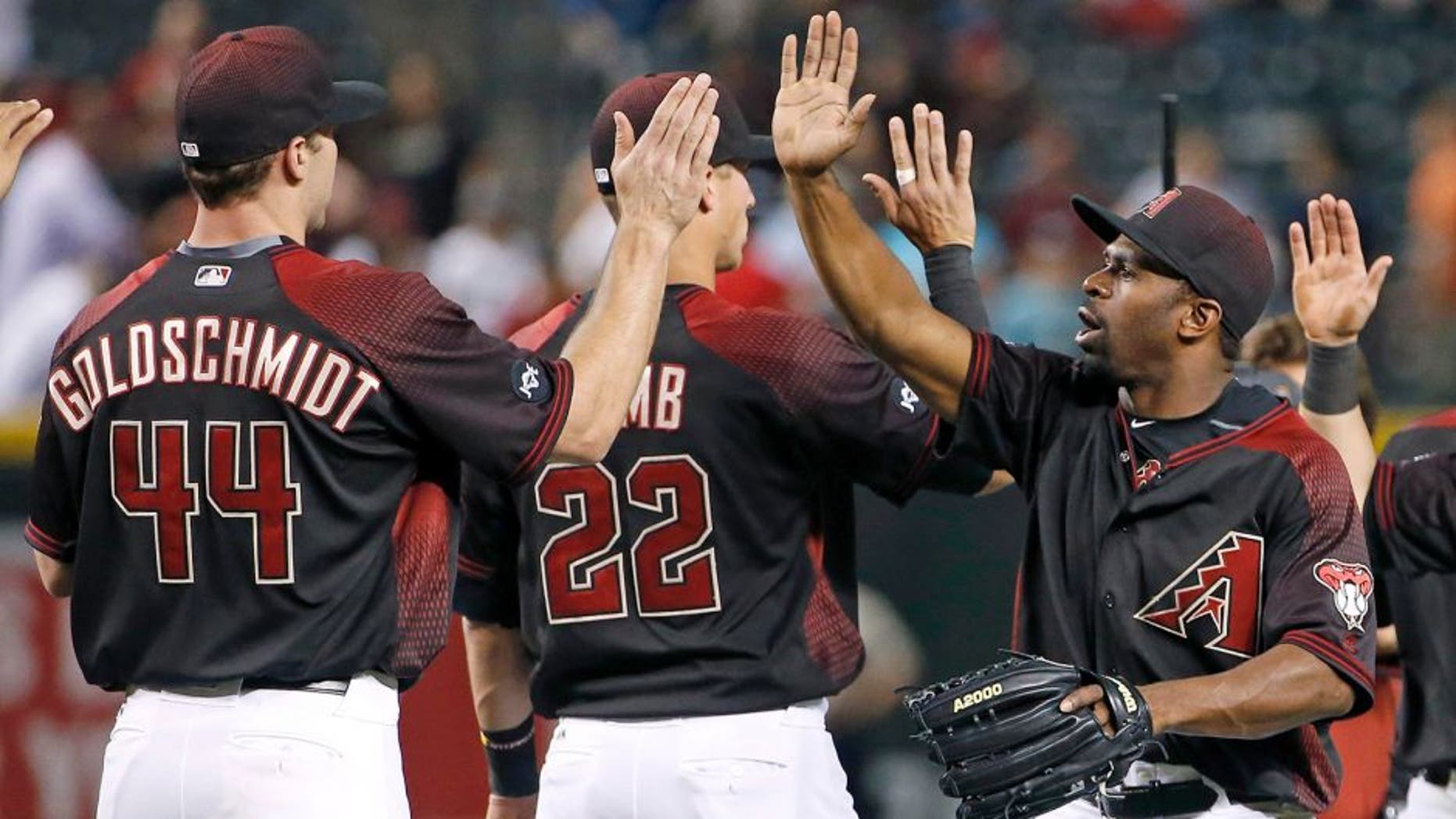 Arizona Diamondbacks' Michael Bourn, right, high-fives with Jake Lamb (22) and Paul Goldschmidt (44) after the final out in the ninth inning of a baseball game against the San Diego Padres Saturday, May 28, 2016, in Phoenix. The Diamondbacks defeated the Padres 8-7. (AP Photo/Ross D. Franklin)