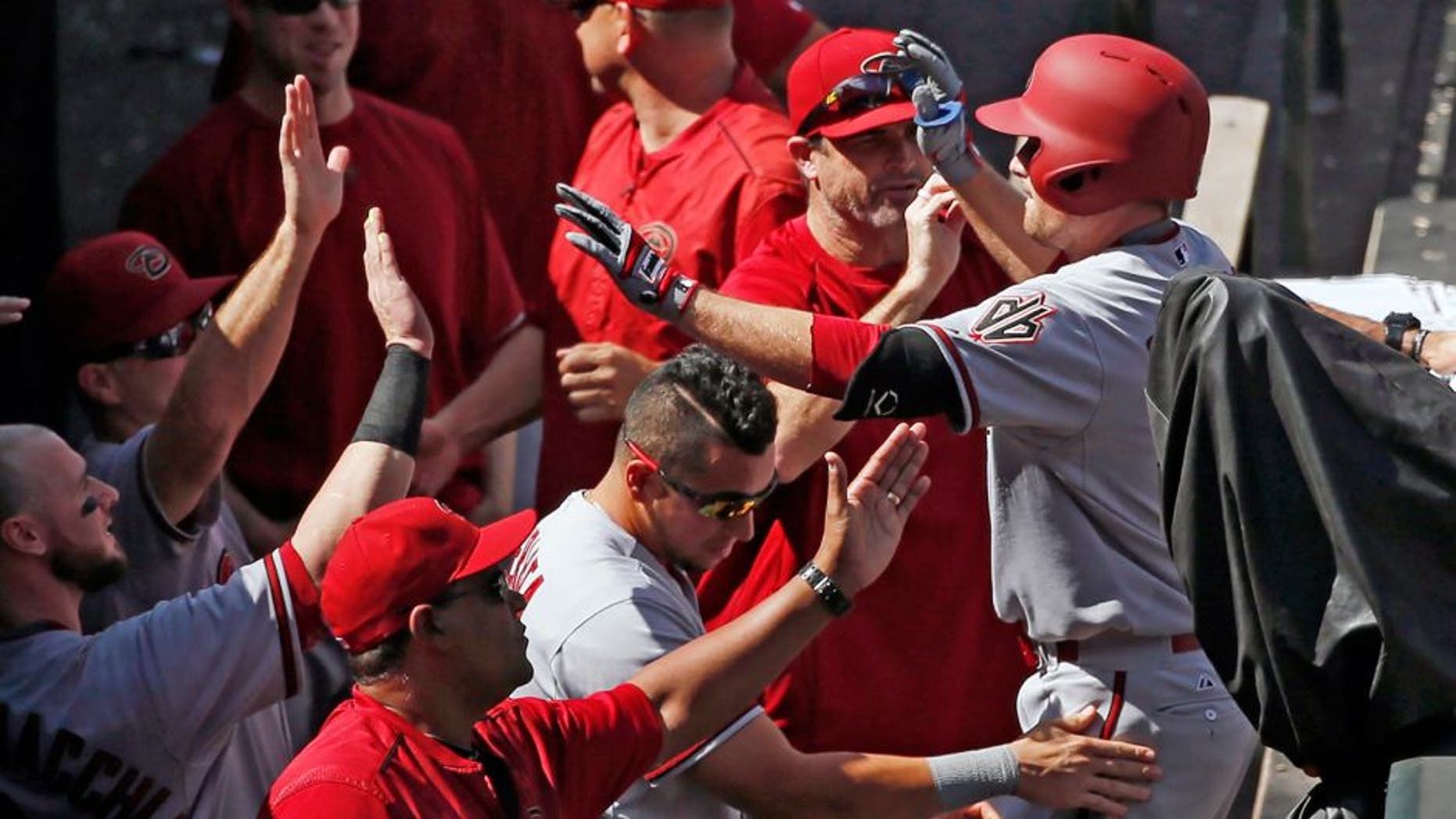 Arizona Diamondbacks' Phil Gosselin is congratulated by teammates as he enters the dugout after hitting a three run home run off the Colorado Rockies during the seventh inning of the first game of a baseball double header Tuesday, Sept. 1, 2015, in Denver. (AP Photo/Jack Dempsey)