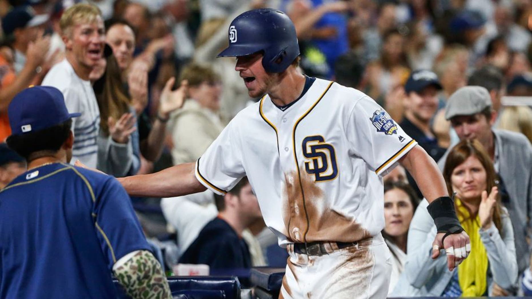San Diego Padres' Wil Myers is congratulated at the dugout after scoring against the New York Yankees during the sixth inning of a baseball game Saturday, July 2, 2016, in San Diego. (AP Photo/Lenny Ignelzi)
