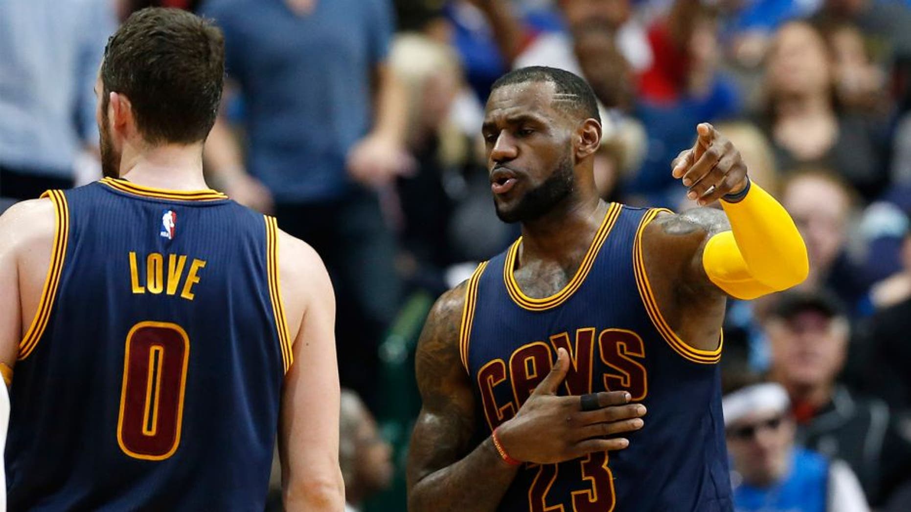 Mar 10, 2015; Dallas, TX, USA; Cleveland Cavaliers forward LeBron James (23) talks with forward Kevin Love (0) during a timeout from the game against the Dallas Mavericks at American Airlines Center. The Cavs beat the Mavs 127-94. Mandatory Credit: Matthew Emmons-USA TODAY Sports
