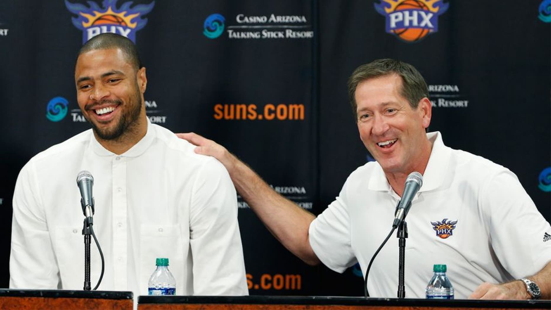 Phoenix Suns' Tyson Chandler, left, the newly signed free agent, laughs along with head coach Jeff Hornacek, right, as Chandler is introduced to the media during a news conference Thursday, July 9, 2015, in Phoenix. (AP Photo/Ross D. Franklin)