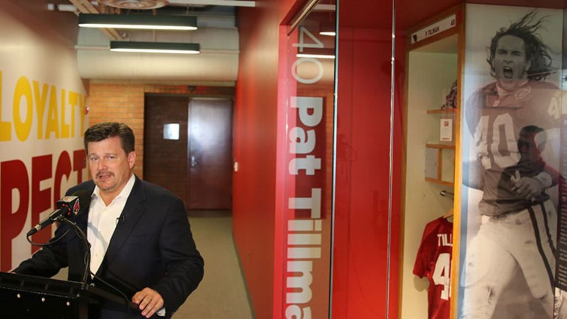 Cardinals president Michael Bidwill talks about the team's training facility renovation while standing next to the Pat Tillman honorary locker.