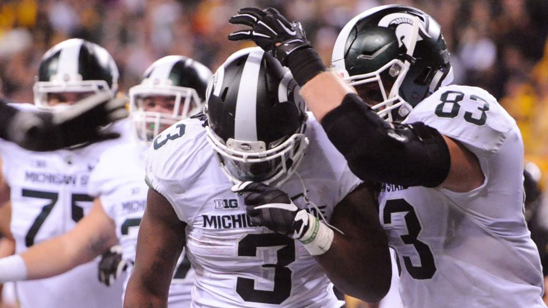 Dec 5, 2015; Indianapolis, IN, USA; Michigan State Spartans running back LJ Scott (3) celebrates the game-winning touchdown with tight end Paul Lang (83) over the Iowa Hawkeyes during the fourth quarter in the Big Ten Conference football championship game at Lucas Oil Stadium. Michigan State won 16-13. Mandatory Credit: Thomas J. Russo-USA TODAY Sports