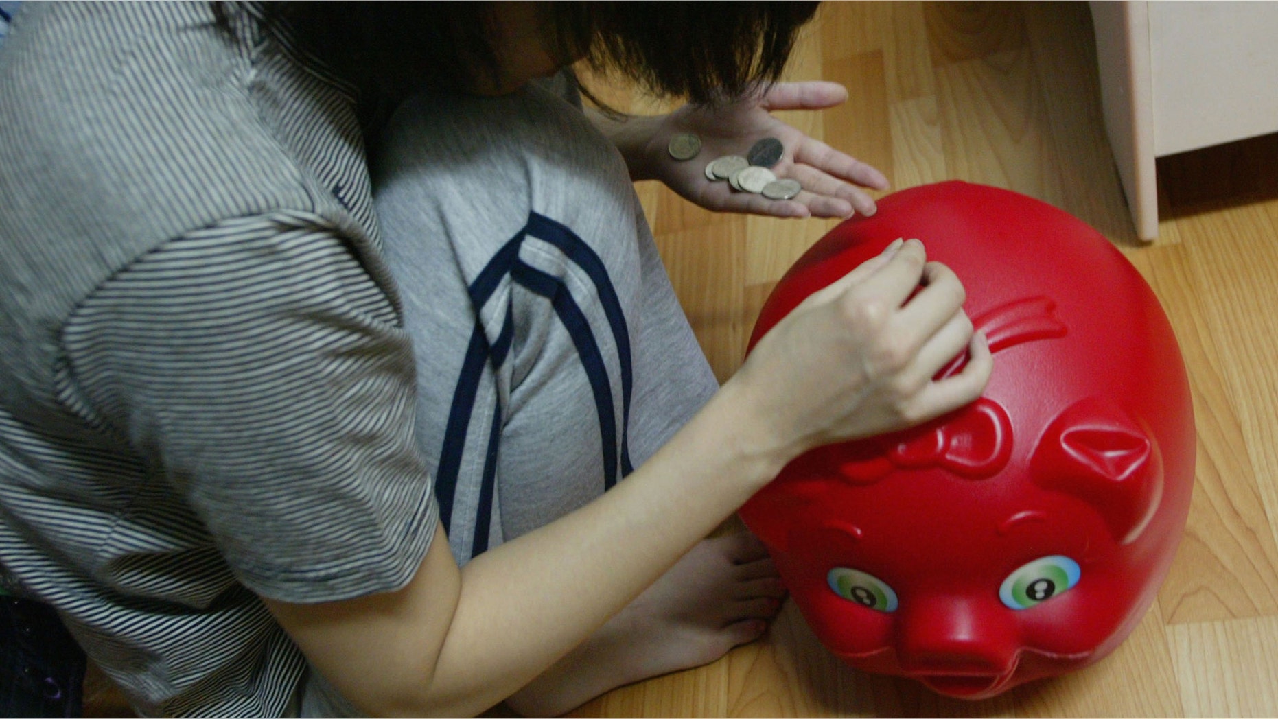 SEOUL, SOUTH KOREA - OCTOBER 19: A South Korean prostitute deposits her money into a piggy-bank in her room on October 19 2004, in Seoul, South Korea. The South Korean government began enforcing new laws last month to target human traffickers, pimps and prostitutes. The sex industry accounts for more than four percent of South Korea's gross domestic product (GDP), with its annual sales estimated at 24 trillion won (21 billion dollars) last year. Statistics show one in five South Korean men buy sex four times a month and 4.1 percent of women aged 20 to 30 rely on prostitution to make a living. (Photo by Chung Sung-Jun/Getty Images)