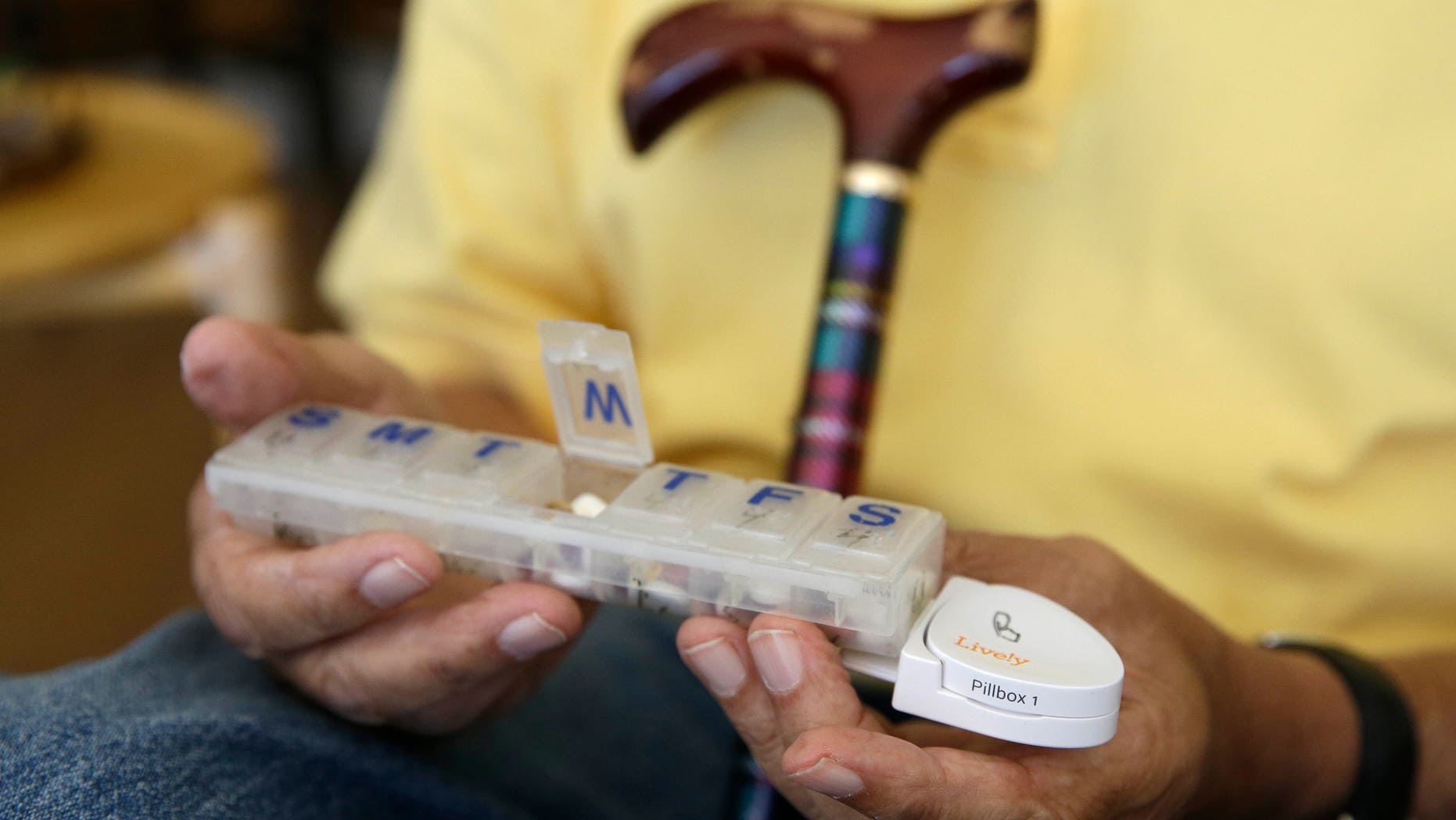 In this March 17, 2015 photo, 81-year-old Bill Dworsky holds his pill container with a motion sensor attached at his home in San Francisco. (AP Photo/Eric Risberg)