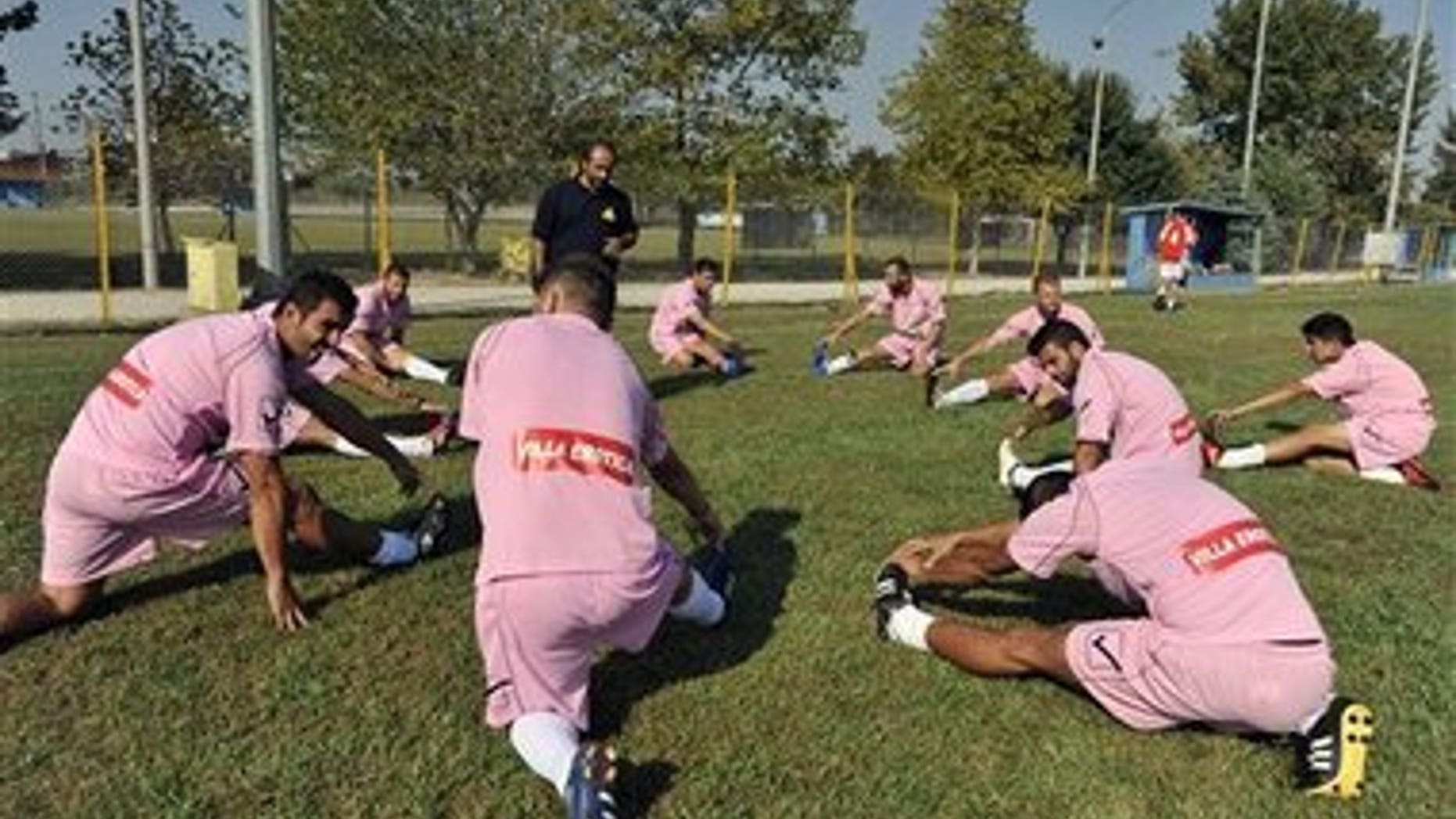 Voukefalas players, a small amateur soccer club, warm up before a local championship match in the city of Larissa, central Greece. A cash-strapped Greek soccer team has found a new way to pay the bills, with help from the world's oldest profession. Players are wearing bright pink practice jerseys emblazoned with the logos of the Villa Erotica and Soulaâs House of History, a pair of pastel-colored bordellos recruited to sponsor the team after drastic government spending cuts left the country's sports organizations facing ruin.