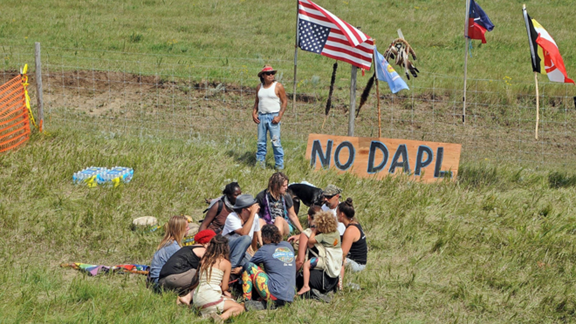 Bill Left Hand, of McLaughlin, South Dakota, stands next to a sign at the site of a protest Friday, Aug. 12, 2016, against construction of the Dakota Access Pipeline that will cross the Missouri River in Morton County.