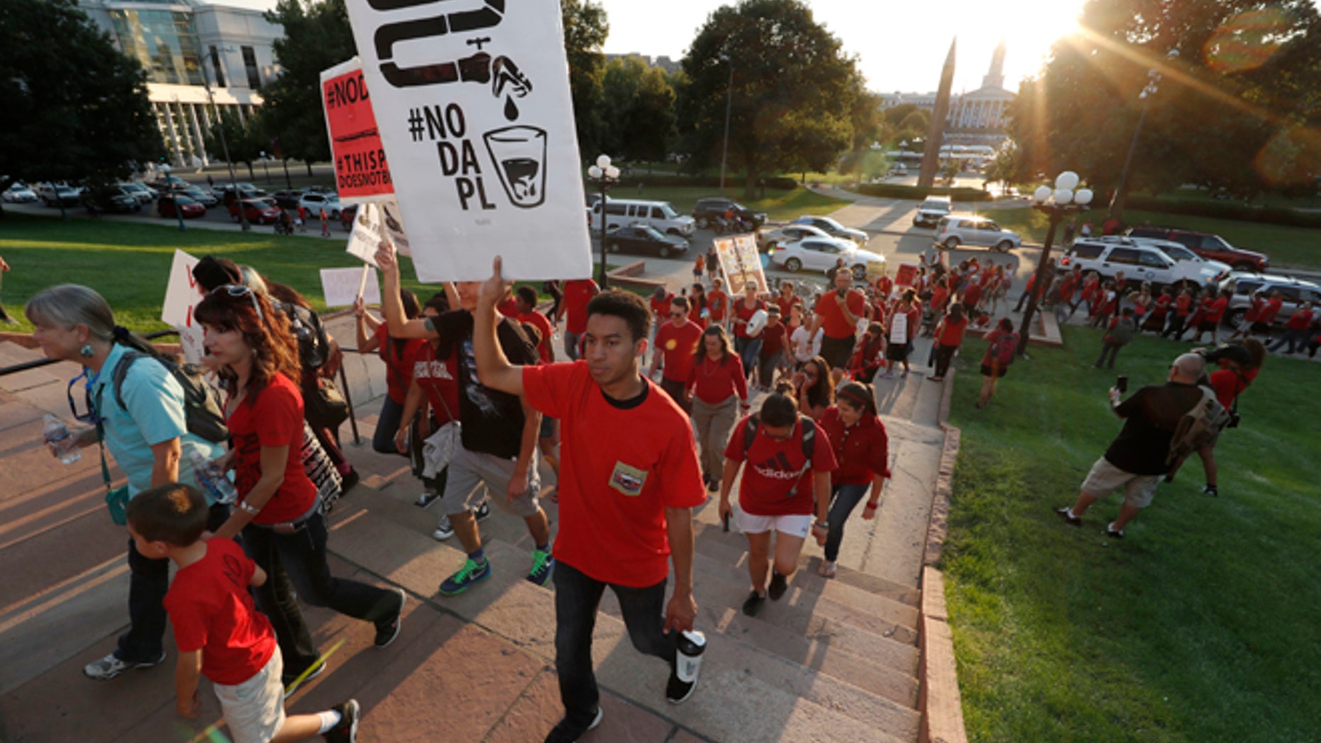 A line of protesters against the construction of the Dakota Access oil pipeline on the Standing Rock Reservation in North Dakota head to a unity rally on the west steps of the State Capitol late Thursday, Sept. 8, 2016, in Denver.