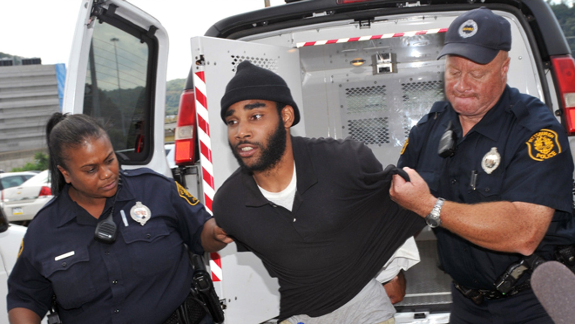 Sept. 21, 2012: Klein Michael Thaxton, center, is lead into Pittsburgh Police headquarters after being apprehended without incident at Three Gateway Center in Pittsburgh.
