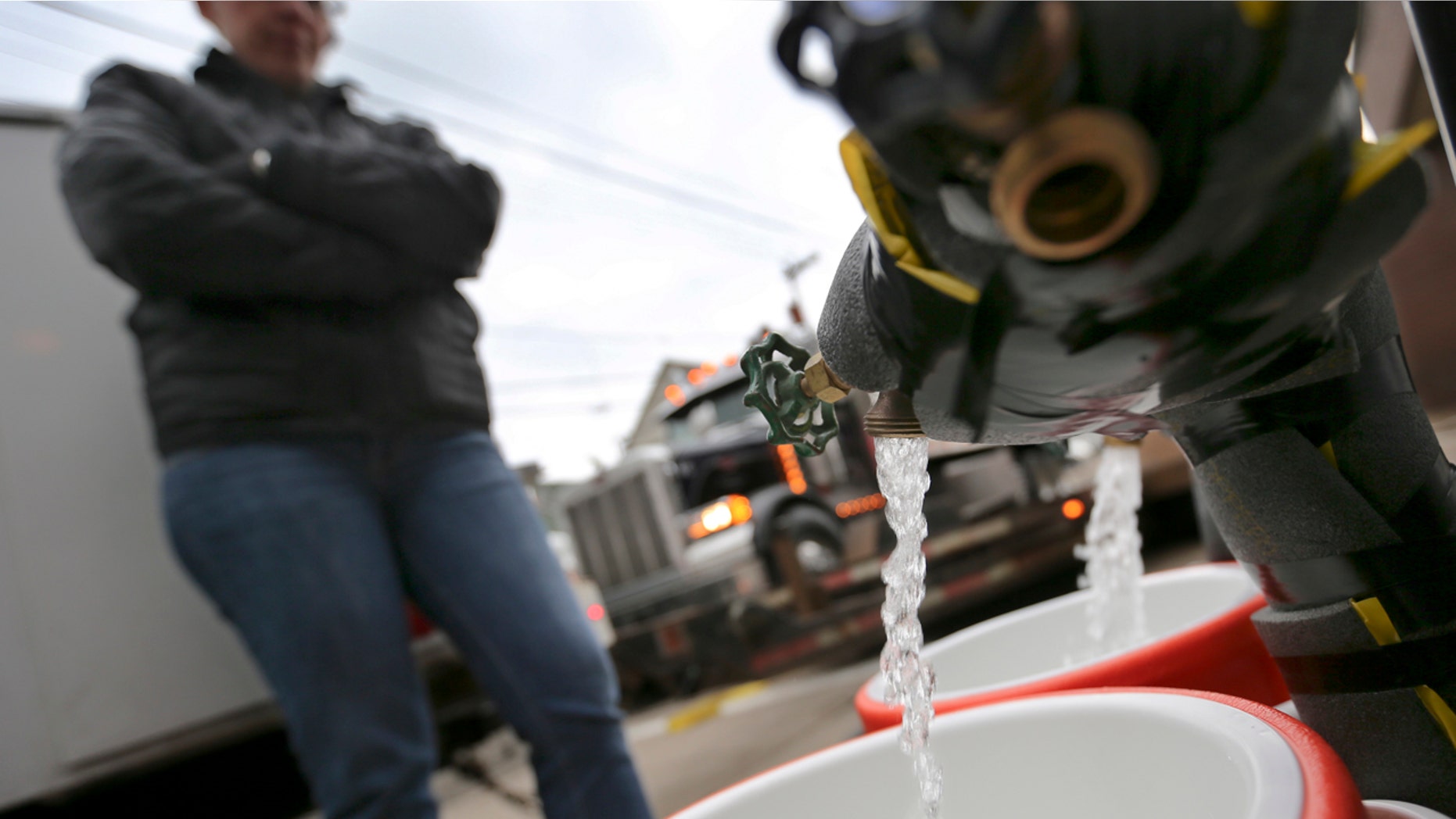 Feb. 1, 2017: Ronette Cooley watches as she fills containers with water at a city fire station in the Lawrenceville section of Pittsburgh.