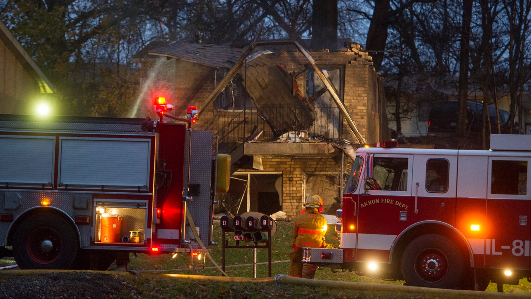 In this Nov. 10, 2015, file photo, firefighters work at the scene where a small business jet crashed into an apartment building in Akron, Ohio.