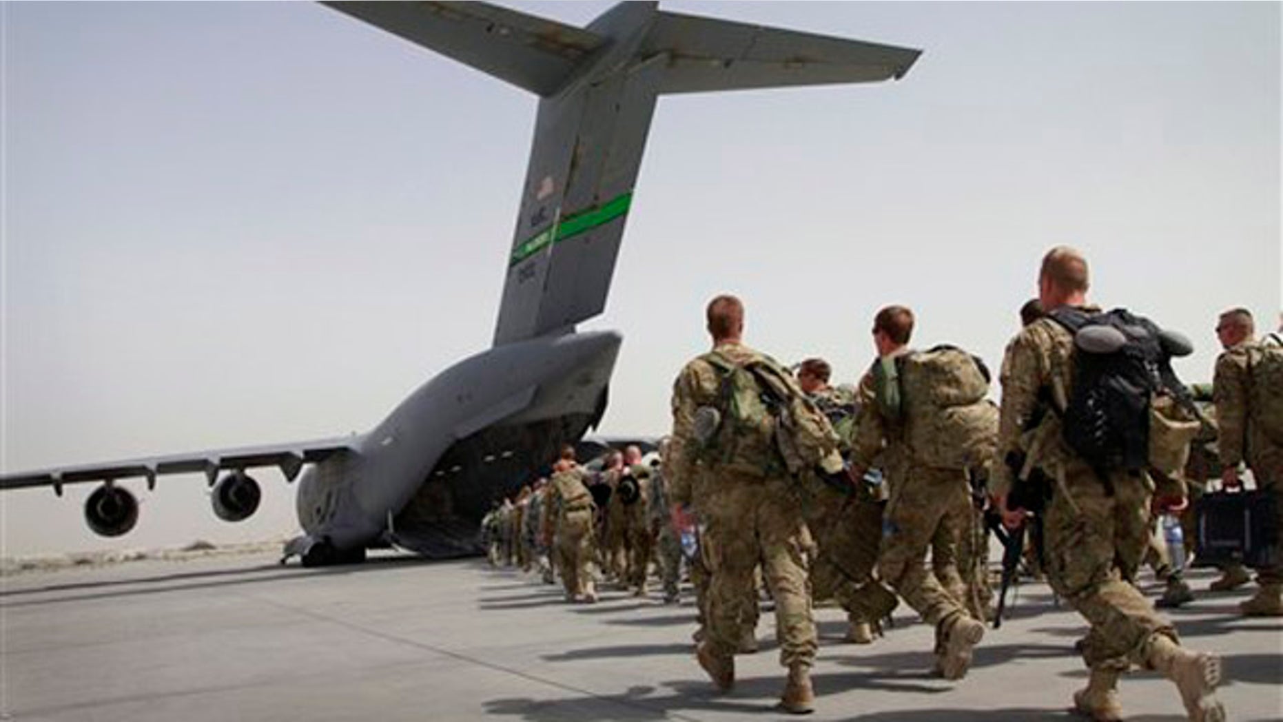 U.S. soldiers walk to board a U.S. military plane, as they leave Afghanistan at the U.S. base in Bagram on July 14.