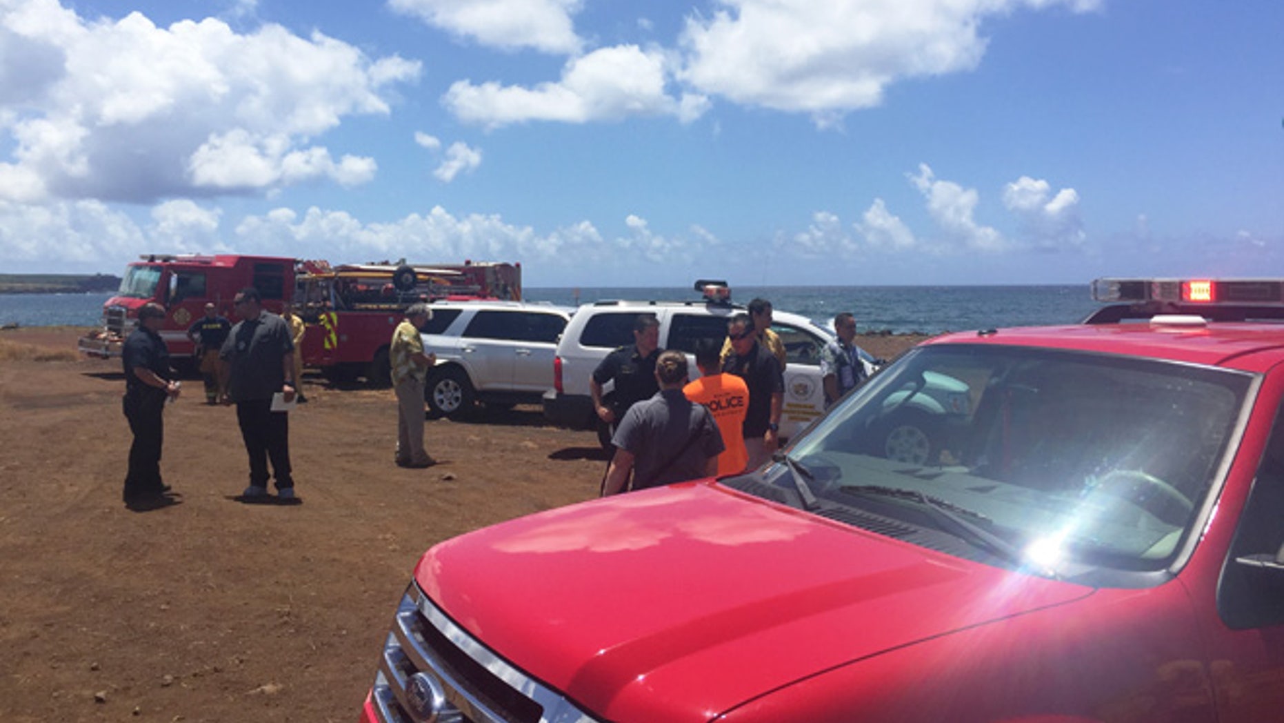 This photo provided by Kauai County shows emergency response vehicles near the site of a plane crash in Hanapepe, Hawaii, on Monday, May 23, 2016. All five people aboard a small plane died in a fiery crash on Kauai, officials said. (Sarah Blane/Kauai County via AP)