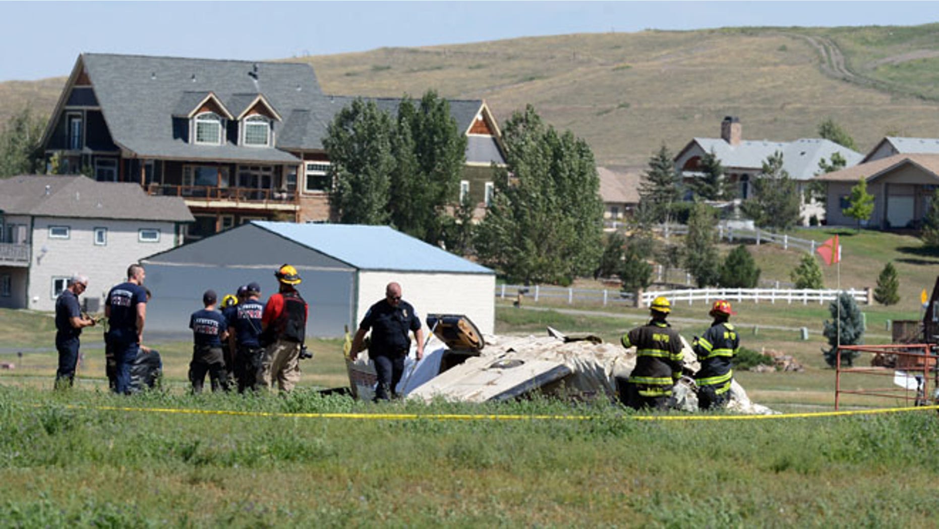 Aug 31, 2014: Police and firefighters work on the scene where three people were killed and two others injured after an airplane crashed in a field northwest of the main runway at Erie Municipal Airport while coming in for a landing in Erie, Colo.