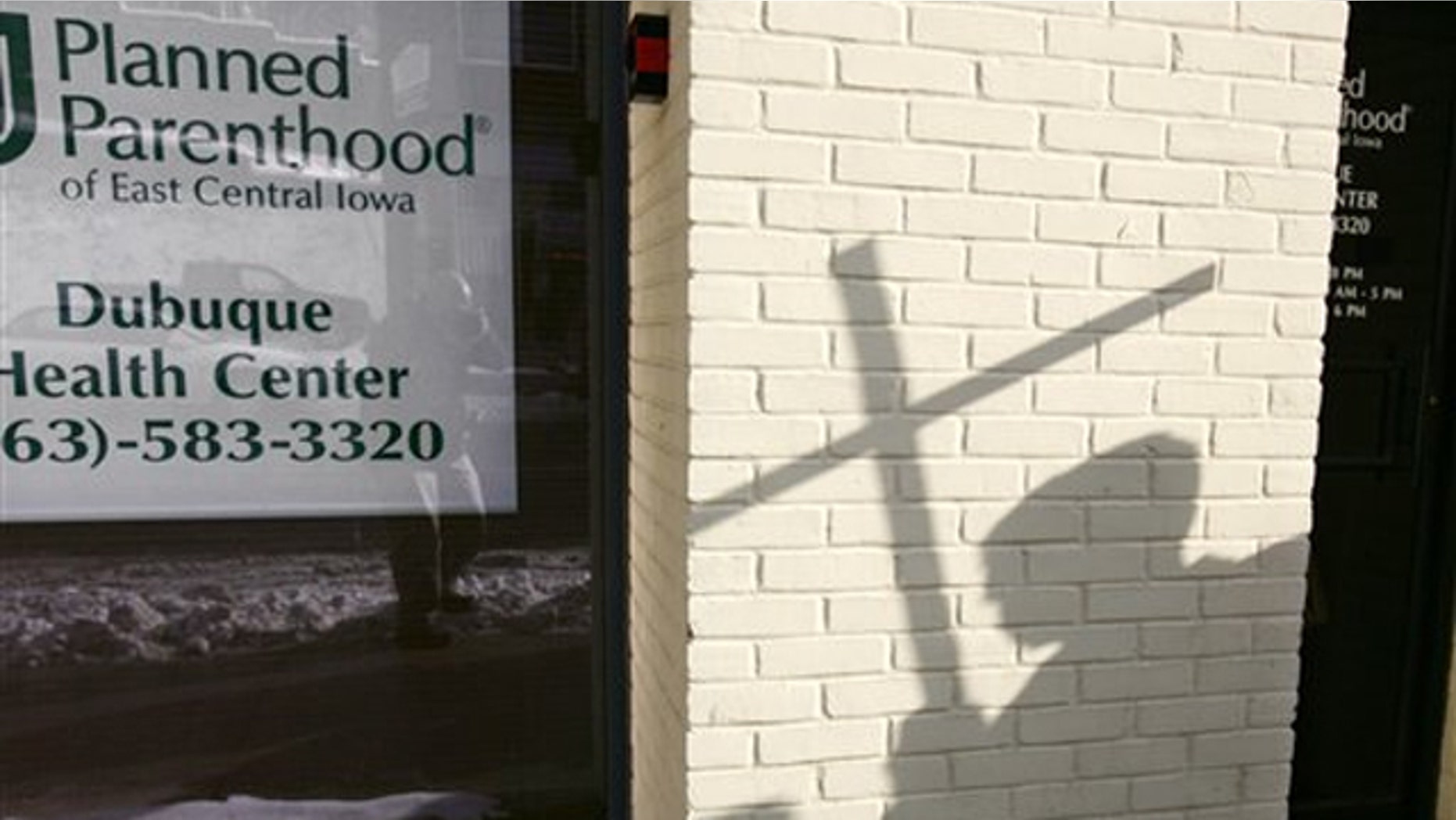 In this Jan. 22, 2009, file photo, the shadow of an anti-abortion activist holding a cross can be seen near a Planned Parenthood in Dubuque, Iowa.
