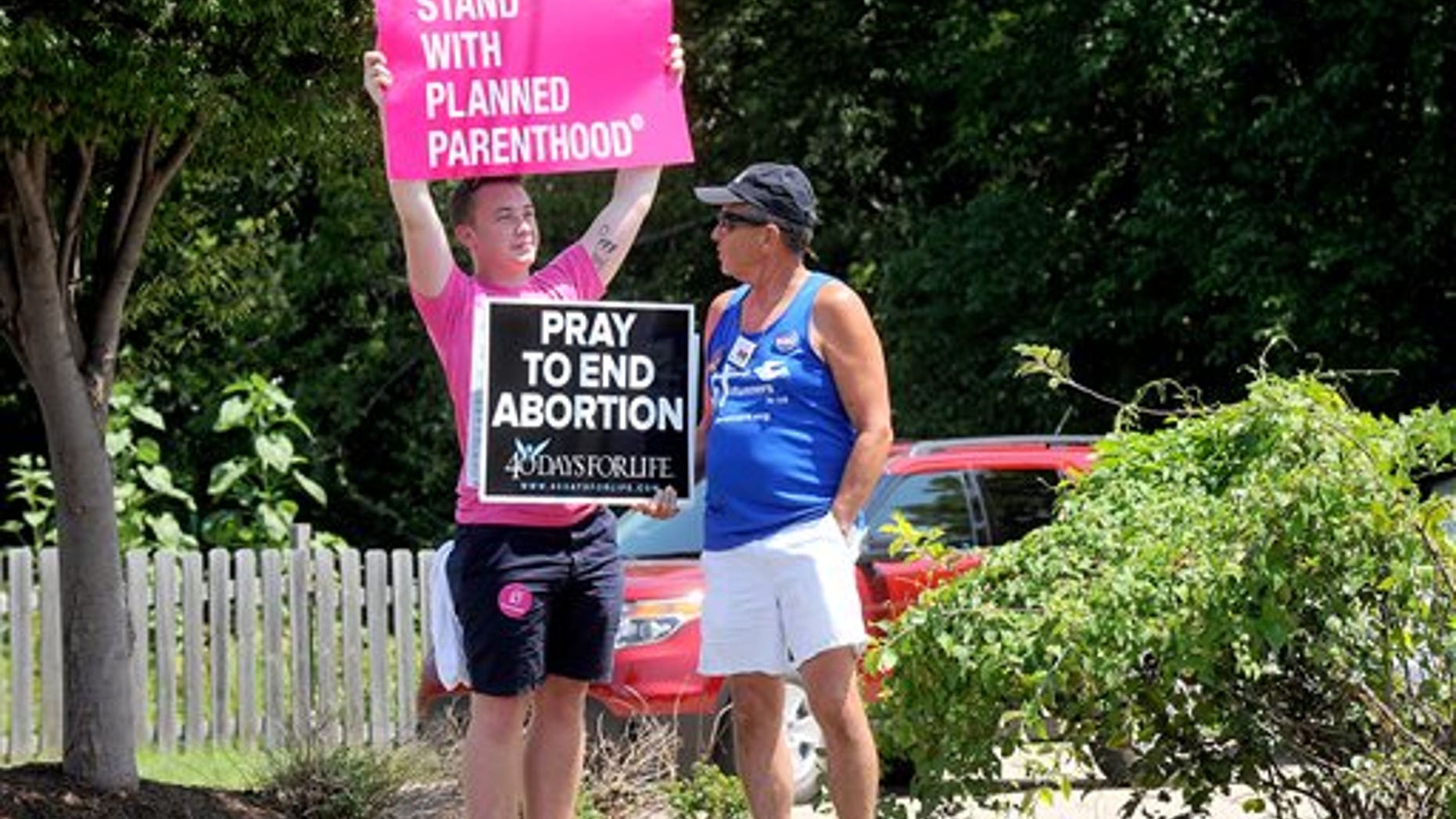 FILE -- July 28, 2015: Andrew Ward, left, and Bill Pauls discuss their positions on abortion during a rally across the street from the Planned Parenthood of Kansas and Mid-Missouri in Columbia, Mo. (Don Shrubshell/Columbia Daily Tribune via AP)