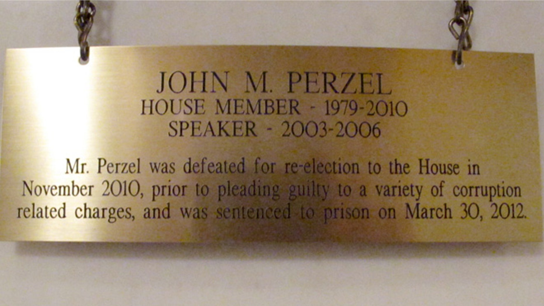 The plaque hanging in the Pennsylvania Capitol below the official portrait of former House Speaker John Perzel and three other former top state lawmakers in Harrisburg, Pa., now includes information about their criminal histories. Plaques that add those details to the dates the four men served were hung Tuesday, July 15, 2014. (AP Photo/Marc Levy)