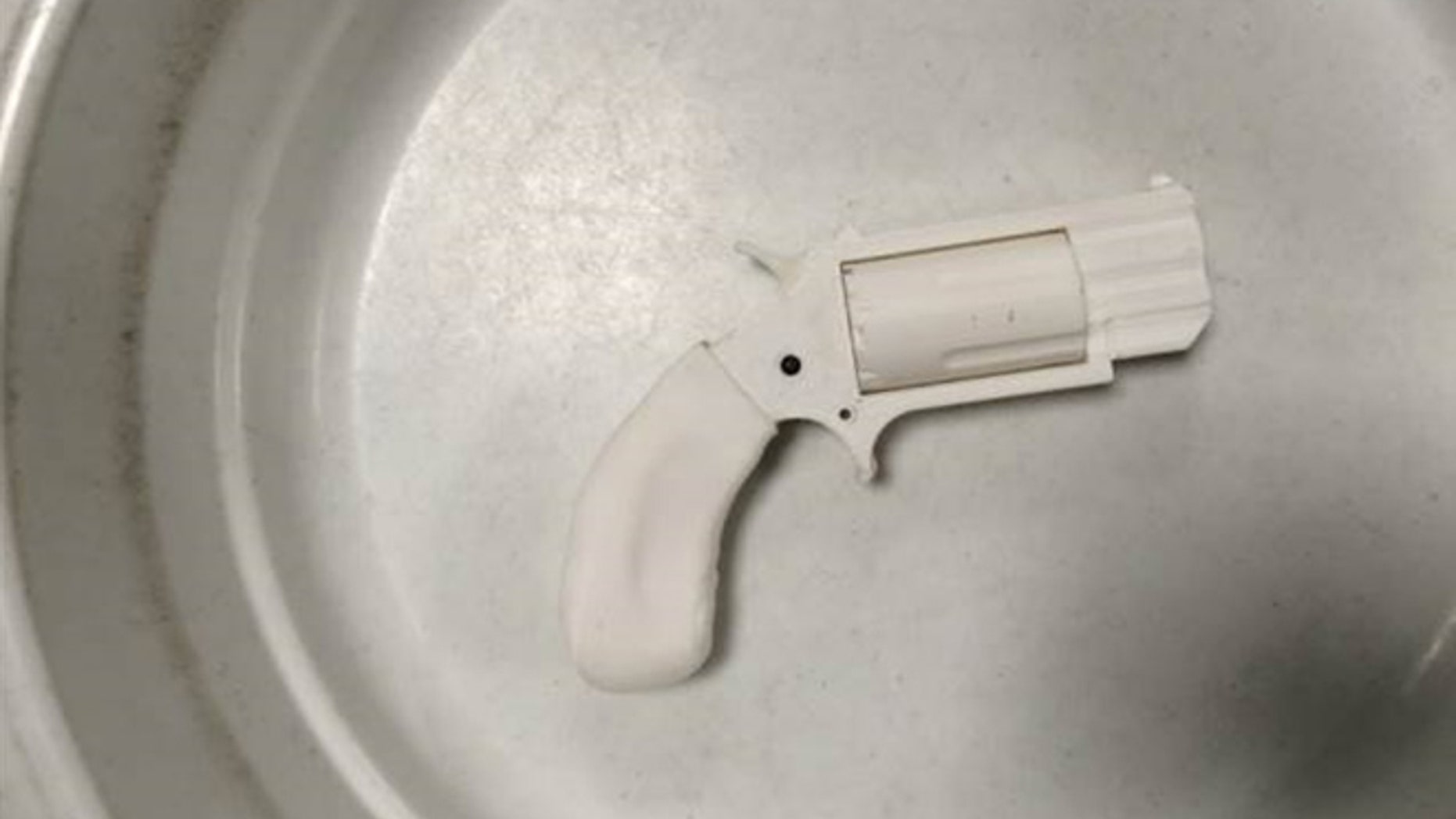 This Aug. 4, 2016, photo, provided by the Transportation Security Administration shows the plastic replica revolver TSA agents recovered from a passenger's carry-on bag at Reno-Tahoe International Airport in a bowl used at the security checkpoint in Reno, Nev.