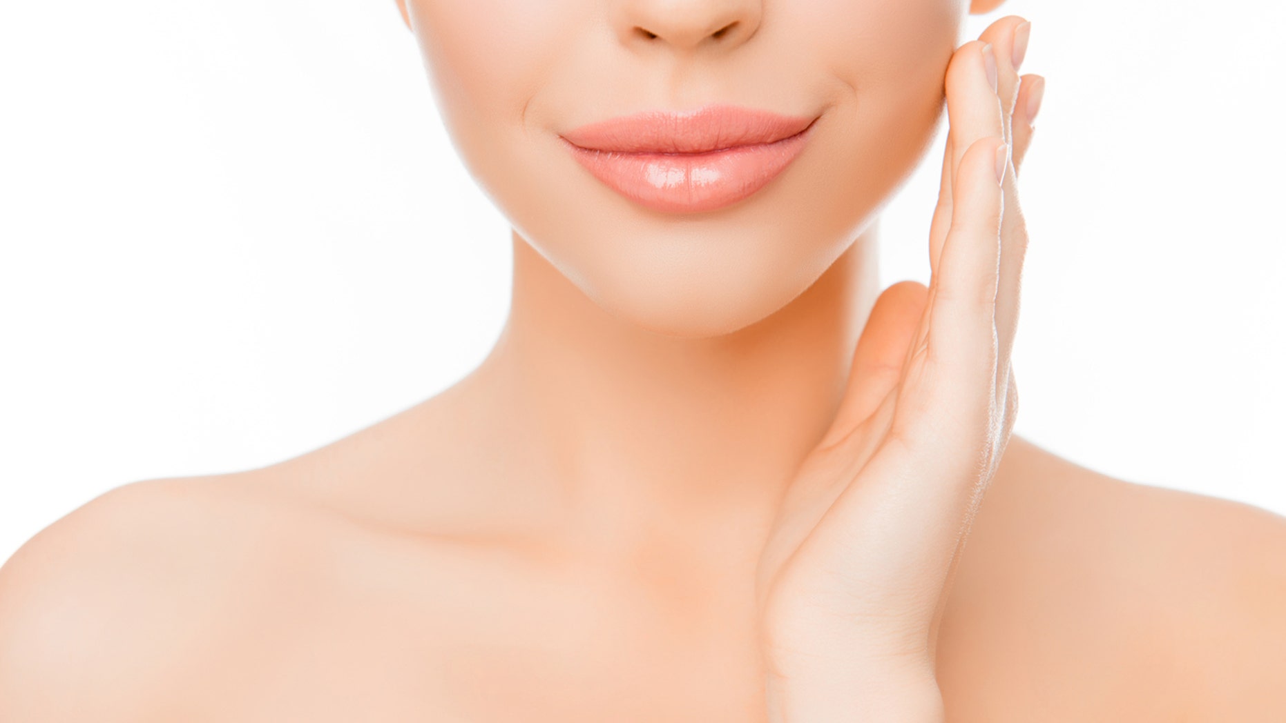 Close up of woman with perfect skin applying cream on face