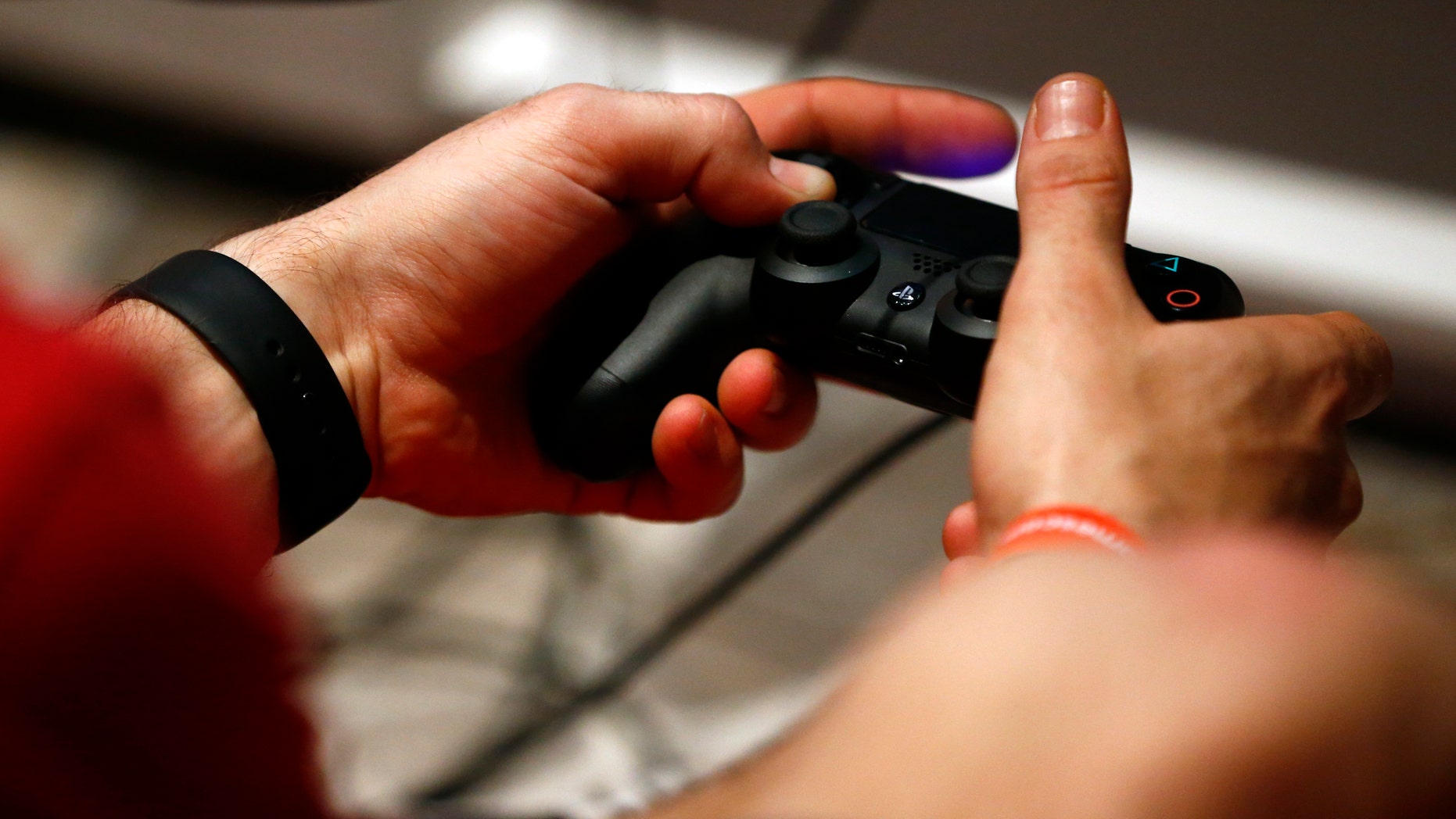 File photo - A man uses a Sony PlayStation controller during the Gamescom 2015 fair in Cologne, Germany Aug. 6, 2015. (REUTERS/Kai Pfaffenbach)