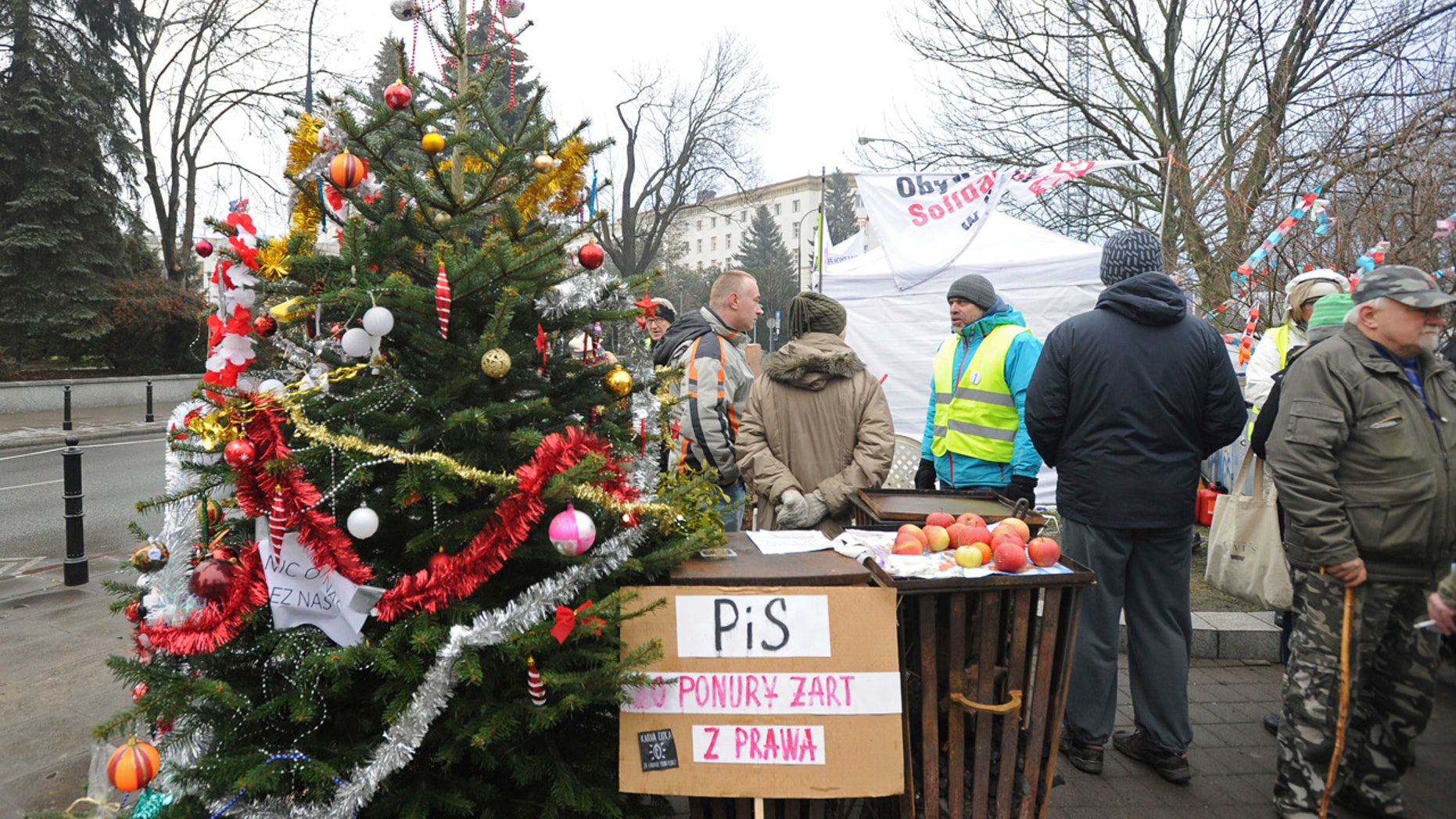 Protesters supporting opposition lawmakers stand next to a Christams Tree in front of the parliament in Warsaw, Poland, Friday, Dec. 23, 2016.