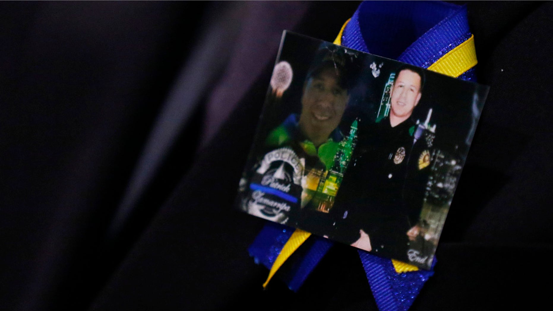 July 16, 2016: A family member wears a ribbon with photos of Patrick Zamarripa during a funeral service for the Dallas police officer