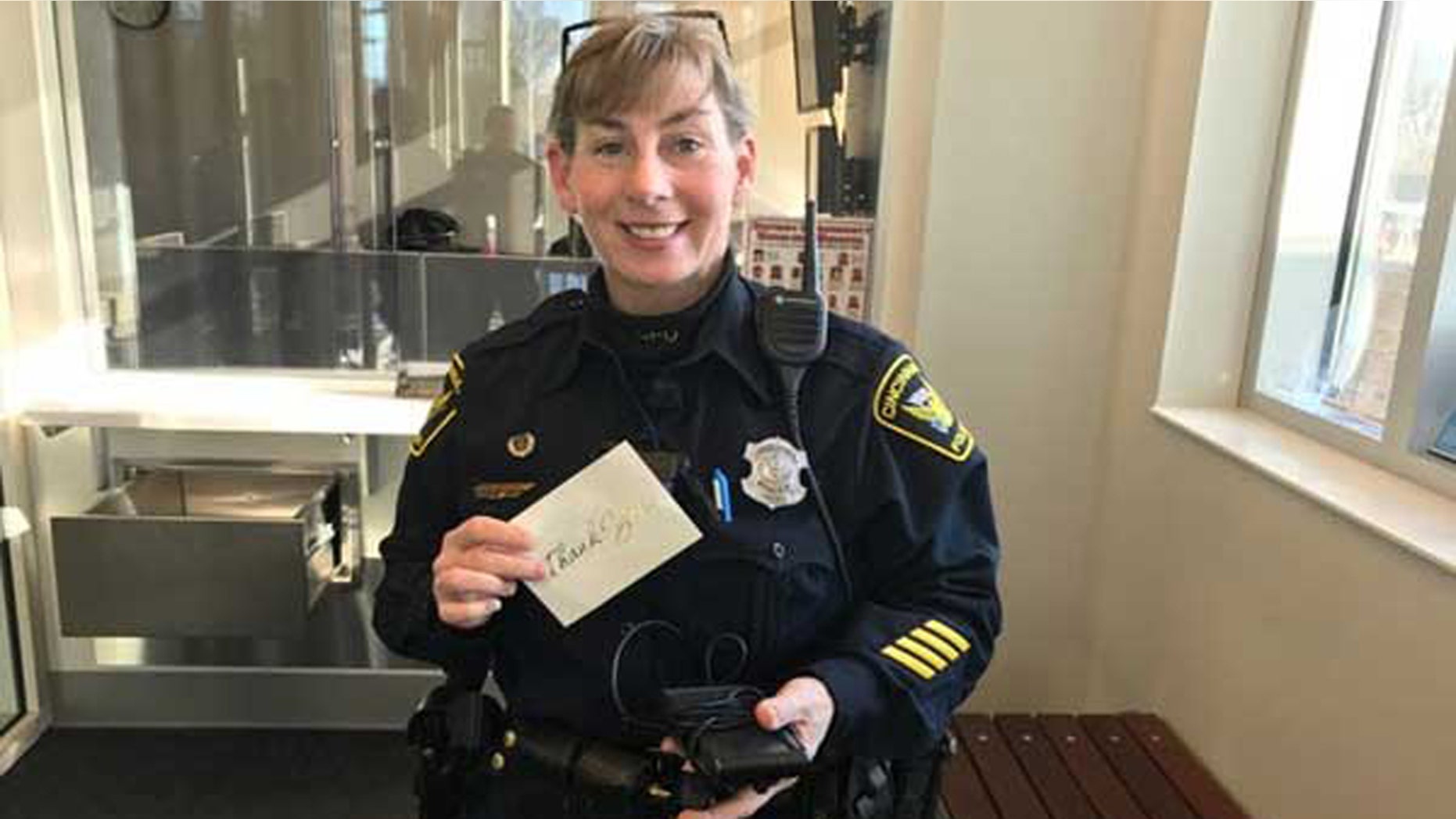 Cincinnati Police Officer Virginia Villing holds the thank you note and GPS system.