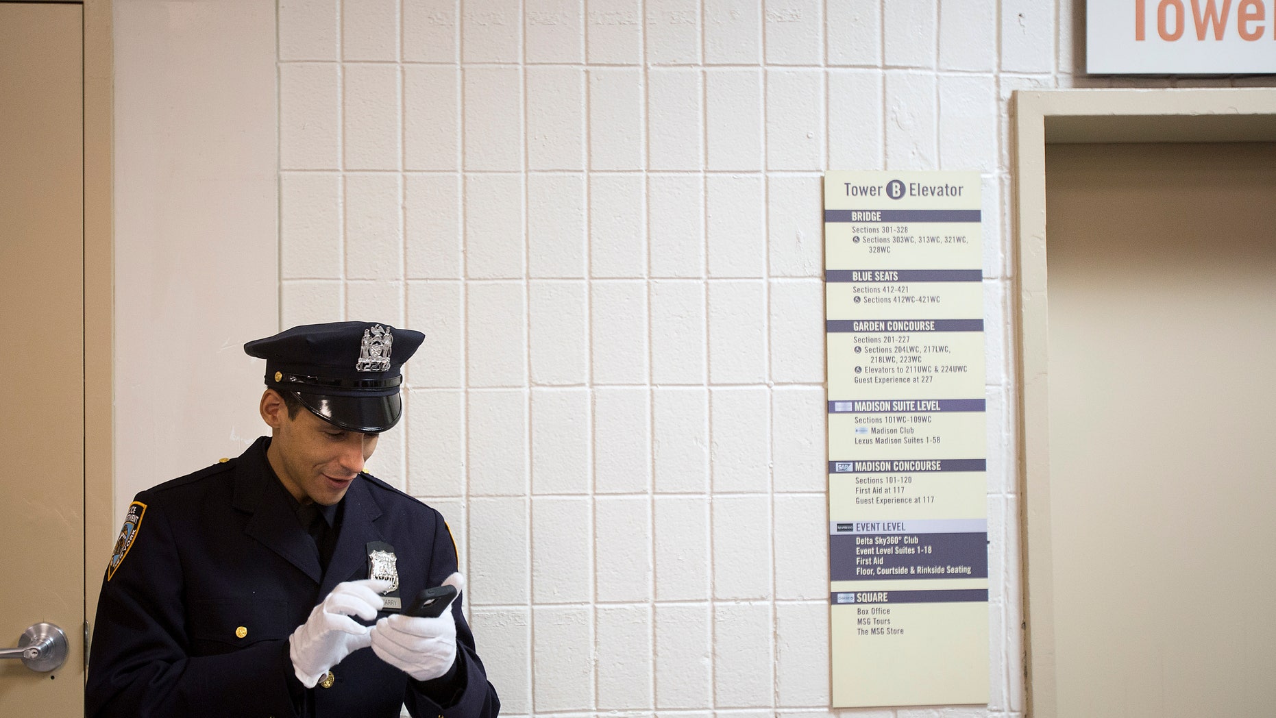 File photo - A New York Police Department graduate video chats on his smartphone backstage before his induction ceremony at Madison Square Garden in New York, December 27, 2013. (REUTERS/Carlo Allegri)