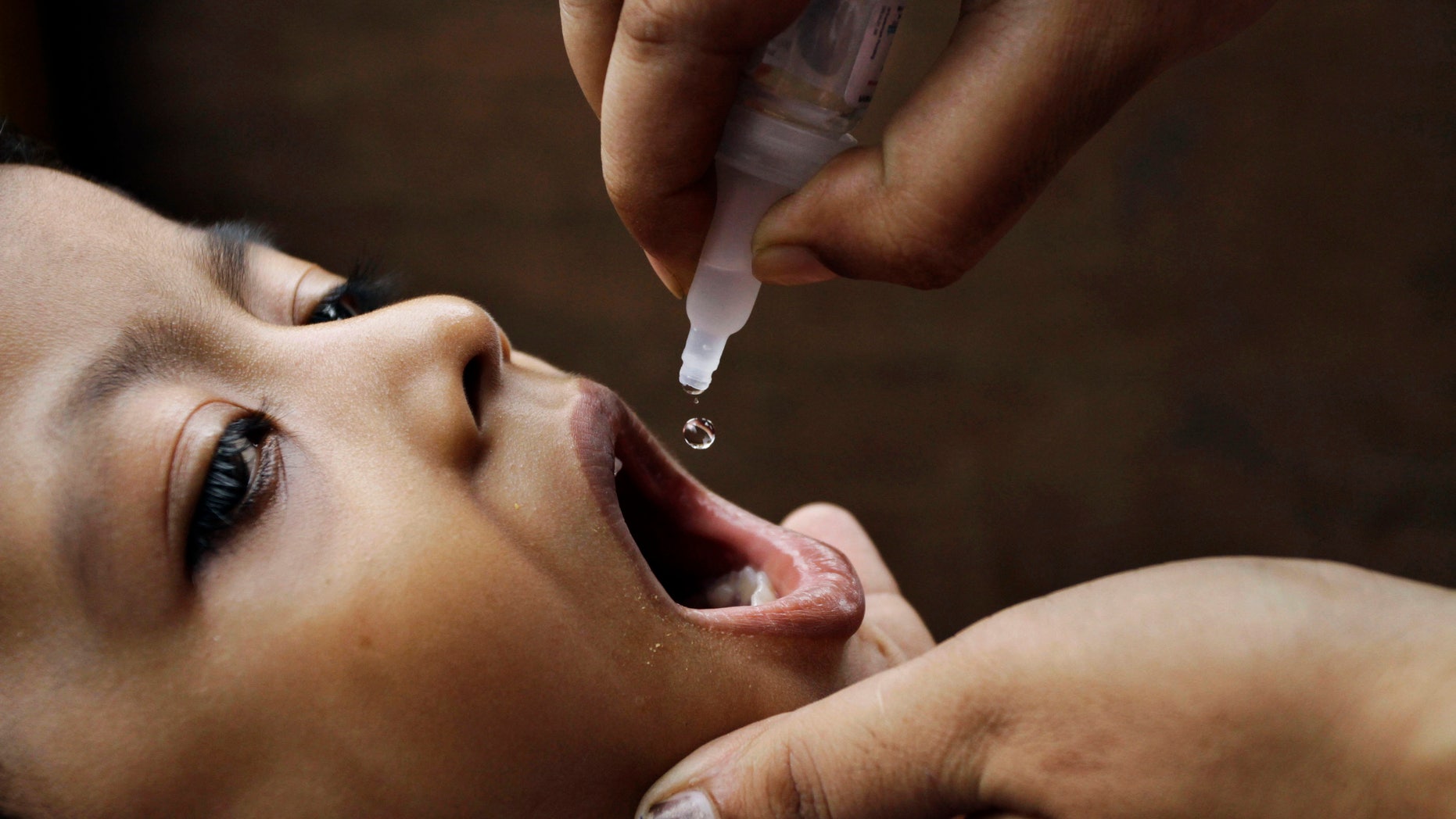 June 17, 2012: In this file photo, a health worker administers a polio drop to an infant in Kolkata, India.