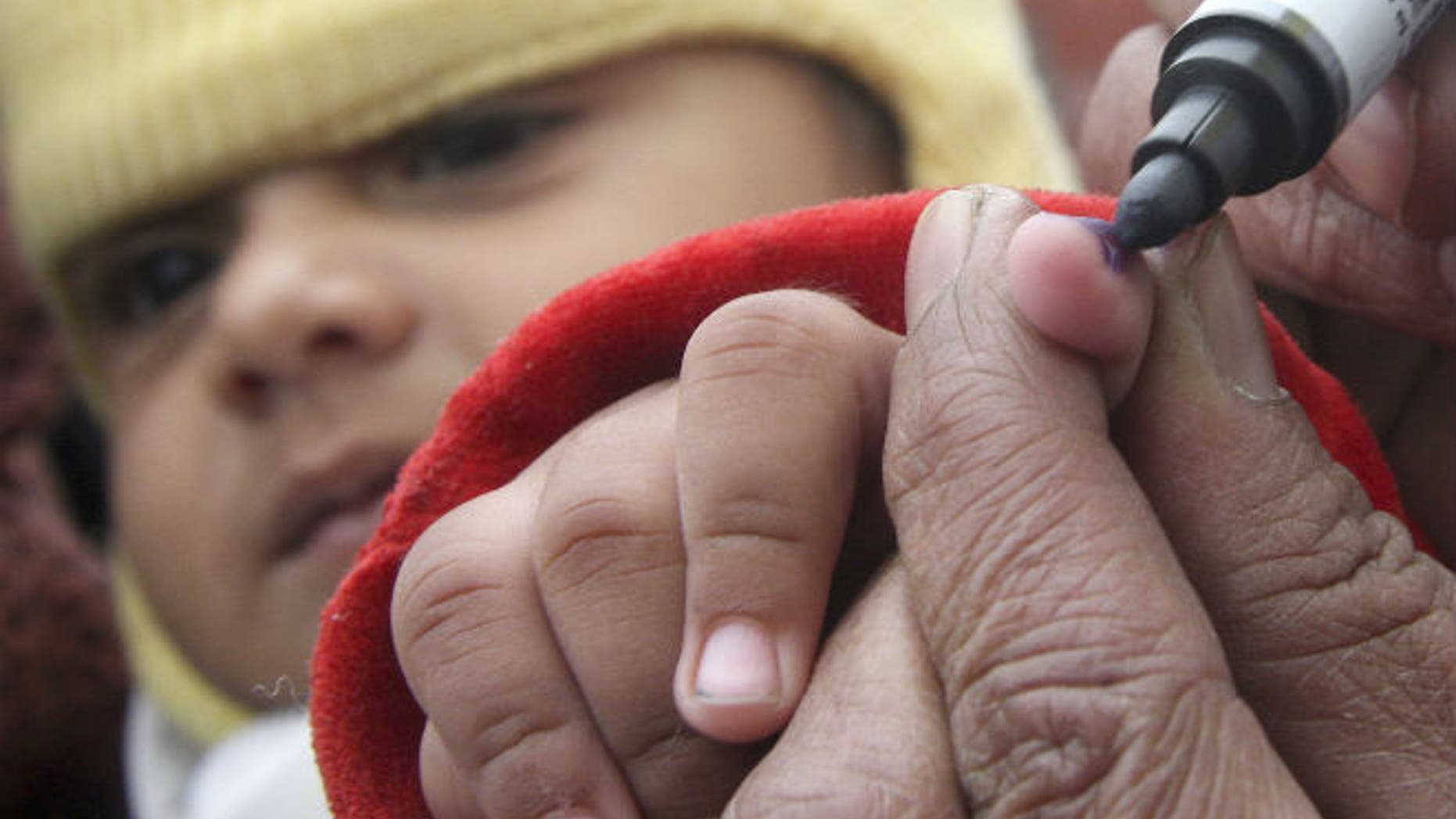 A health worker marks the finger of a child after administering a polio vaccine at a polio booth in the northern Indian city of Chandigarh January 10, 2010. (REUTERS/Ajay Verma)
