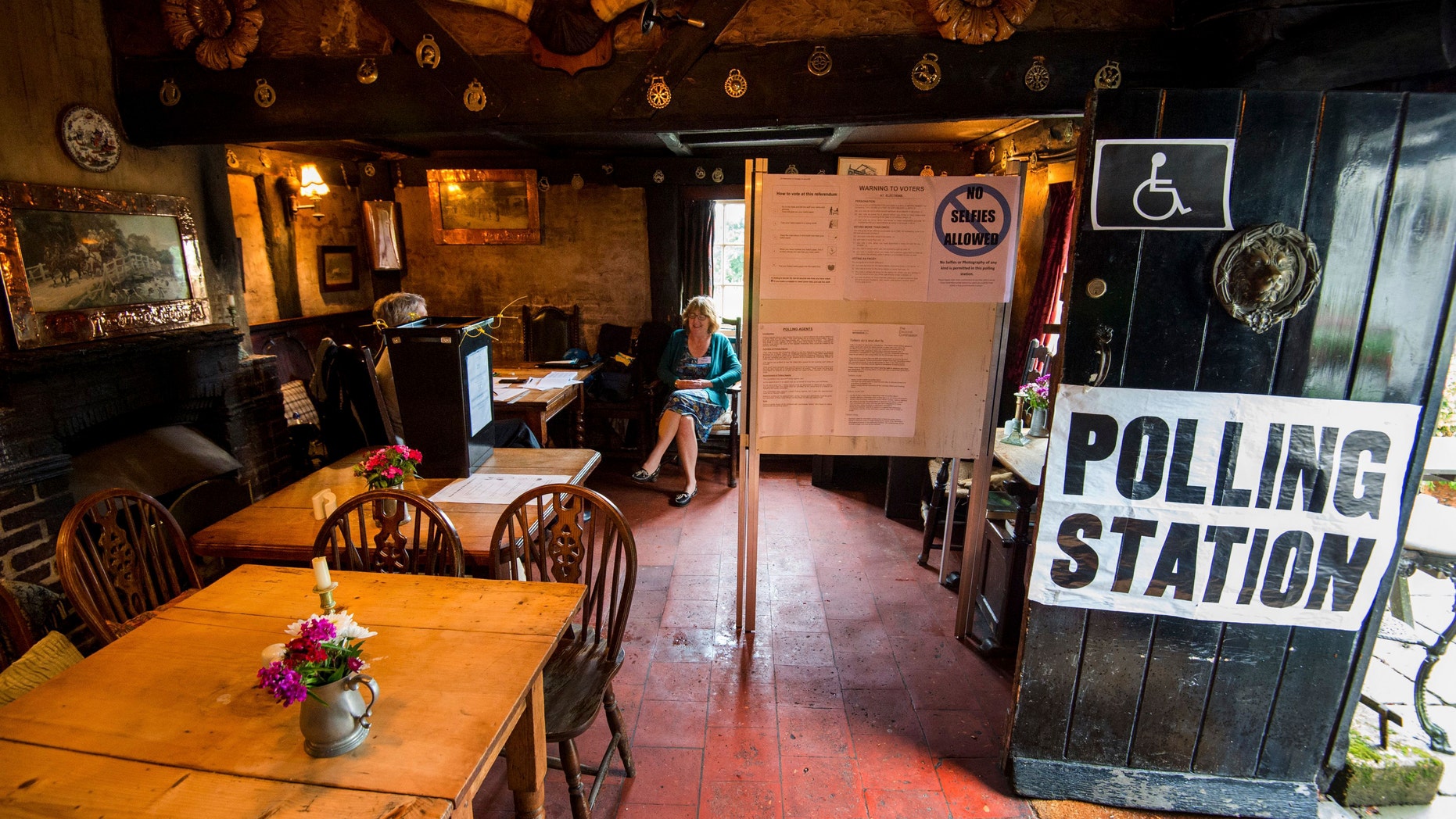 The scene inside the White Horse Inn in Priors Dean, Hampshire, England also known as the 'Pub with no name' which has been made a polling station for the EU referendum Thursday June 23, 2016. Voters in Britain are deciding Thursday whether the country should remain in the European Union. (Andrew Matthews/PA via AP)