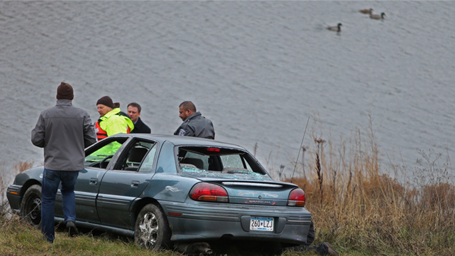 Nov. 21, 2013: Photo investigators look at a car that veered off a suburban Minneapolis highway ramp and plunged into a storm water pond with five children, ages 1 to 7, aboard.