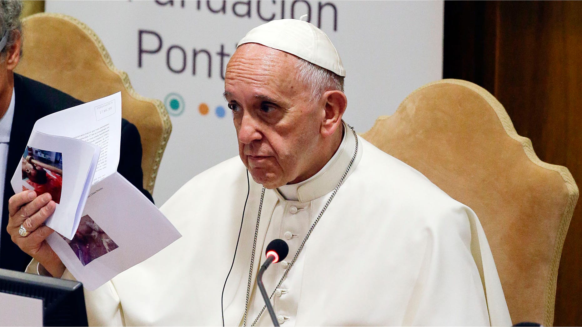 Pope Francis show pictures of killed children during a meeting with the Scholas Occurrentes, an educational organization founded by the Pontiff, at the Vatican, Sunday, May 29, 2016. (AP Photo/Gregorio Borgia)