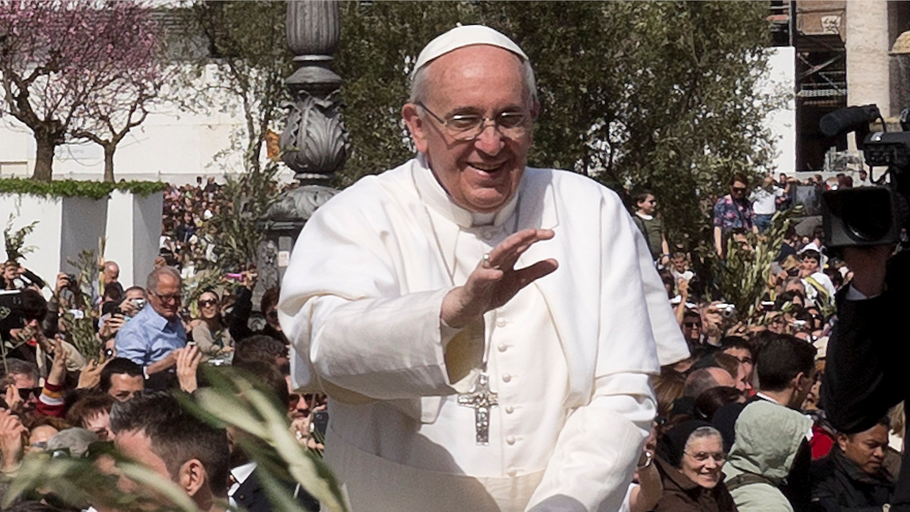 March 24, 2013: Pope Francis waves at a cheering crowd as he wades through St. Peter's Square at the Vatican.