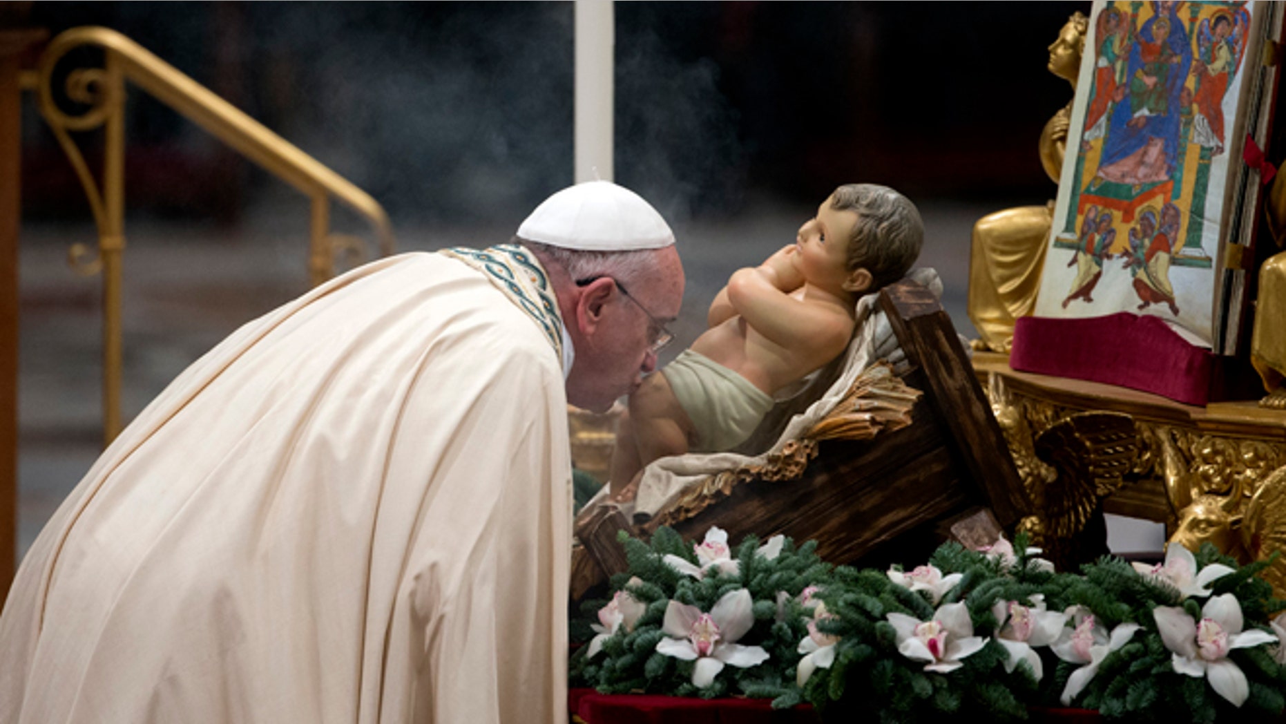 Dec. 31, 2014: Pope Francis kisses a statue of the baby Jesus as he arrives to celebrate the new year's eve vespers Mass in St. Peter's Basilica at the Vatican. (AP)