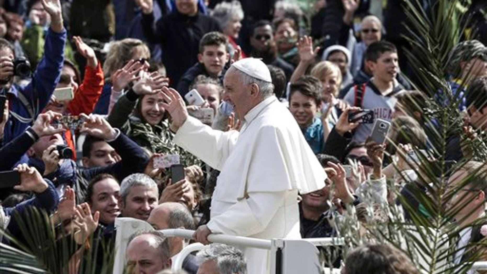 Pope Francis greets faithful after celebrating Palm Sunday Mass, at the Vatican, Sunday, March 20, 2016. Pope Francis in his Palm Sunday homily decried what he called indifference to the refugees flooding into Europe, making a comparison to authorities who washed their hands of Jesus' fate ahead of his crucifixion. (Giuseppe Lami/ANSA via AP)