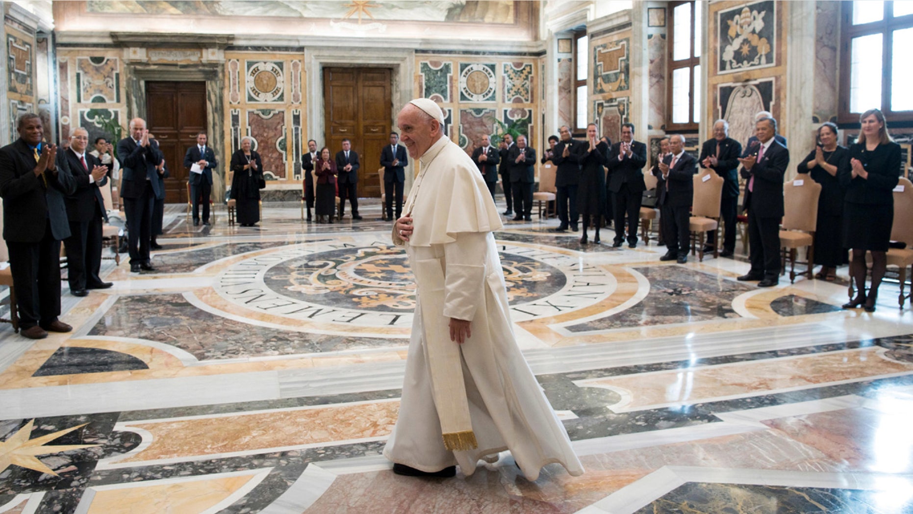Pope Francis walks in the Clementine Hall after meeting with a delegation of Pacific leaders to discuss climate issues at the Vatican.